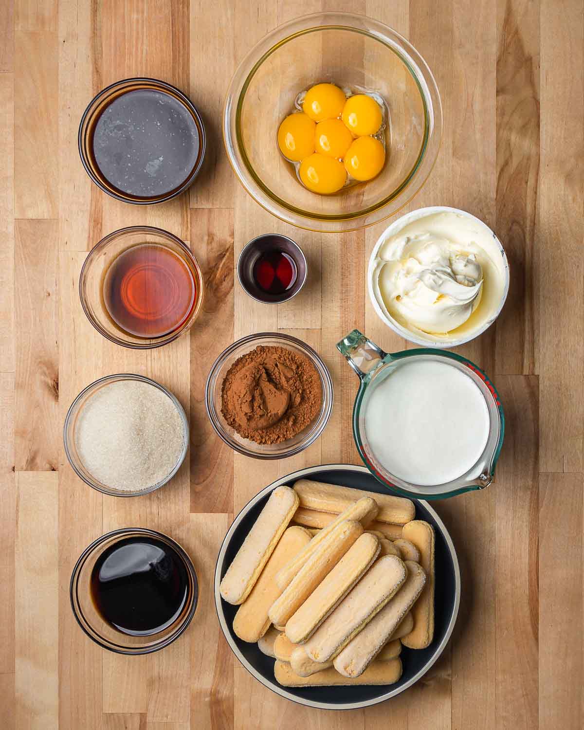 Ingredients shown: espresso, egg yolks, vanilla, marsalla, masacarpone, cocoa powder, kahlua, heavy cream, sugar, and lady fingers cookies.