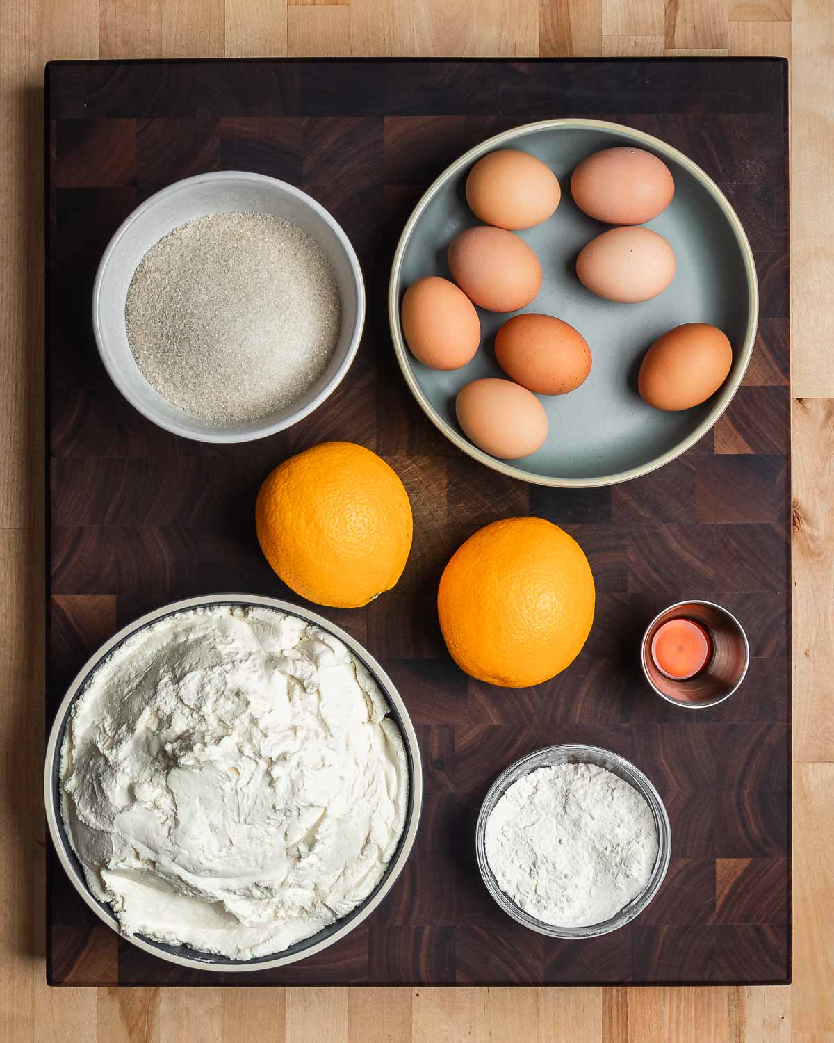 Ingredients shown: sugar, eggs, oranges, vanilla, ricotta, and flour.
