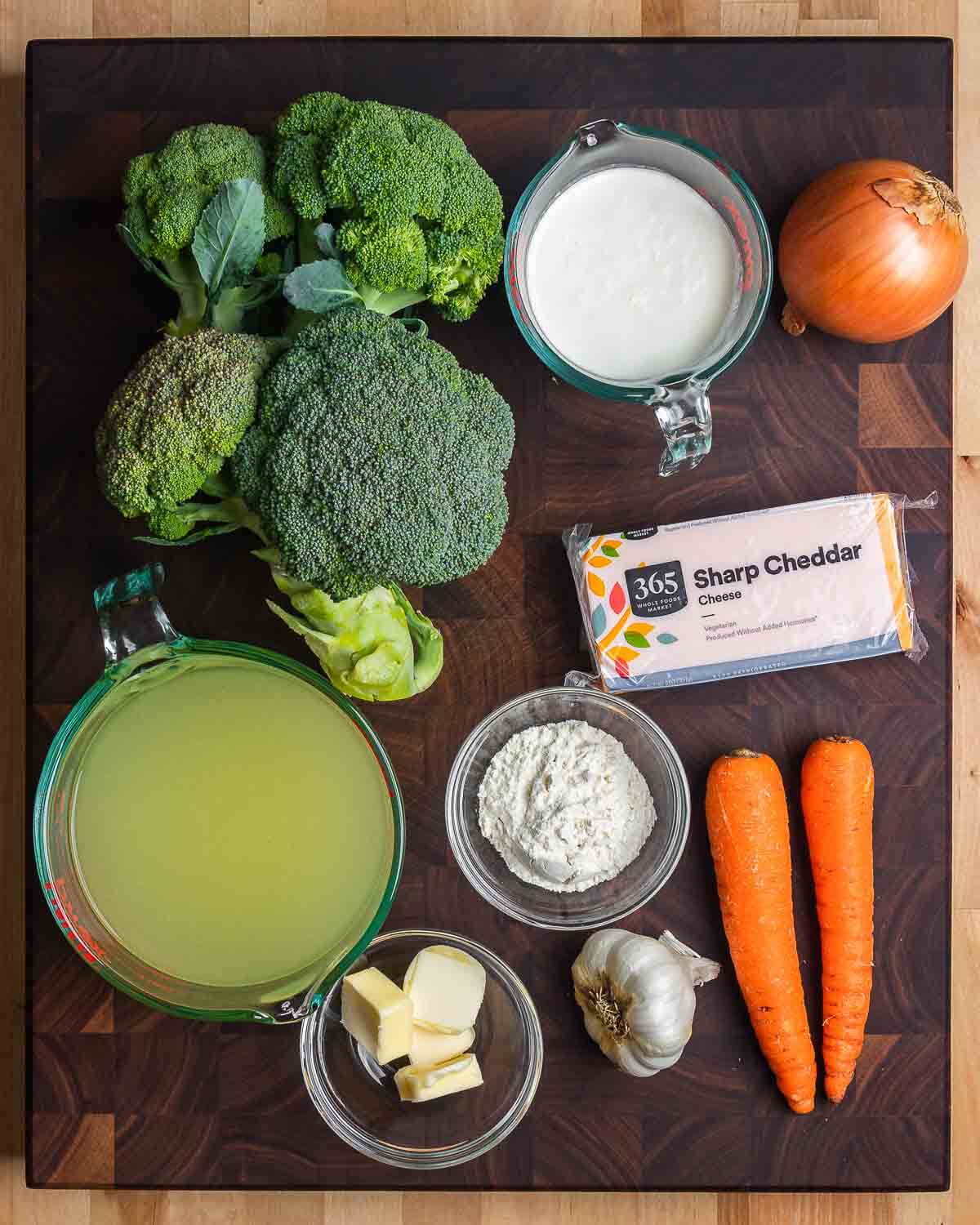 Ingredients shown: broccoli, heavy cream, onion, chicken stock, butter, flour, cheddar cheese, garlic, and carrots.