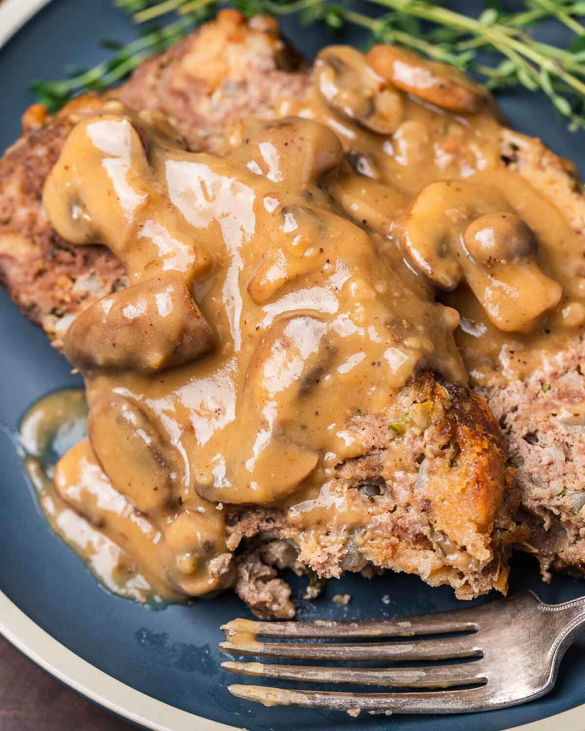 Meatloaf with gravy in blue plate.