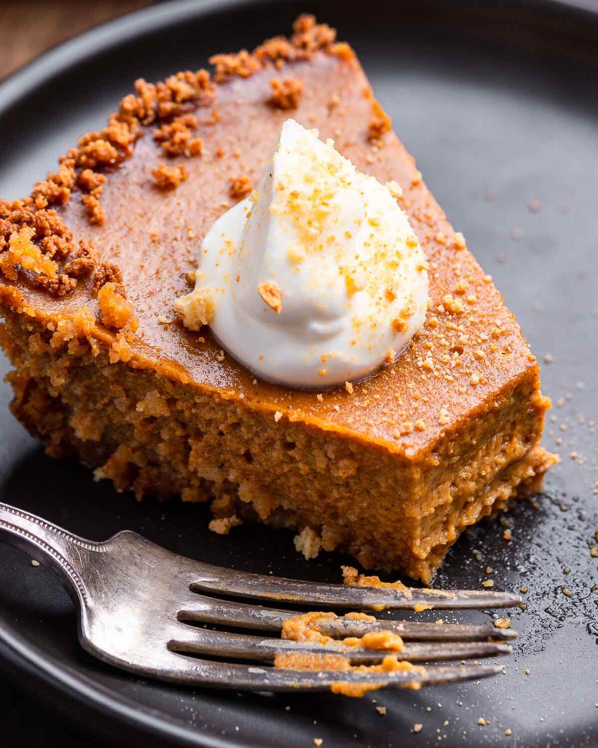 Slice of pumpkin pie with bite taken out of it.