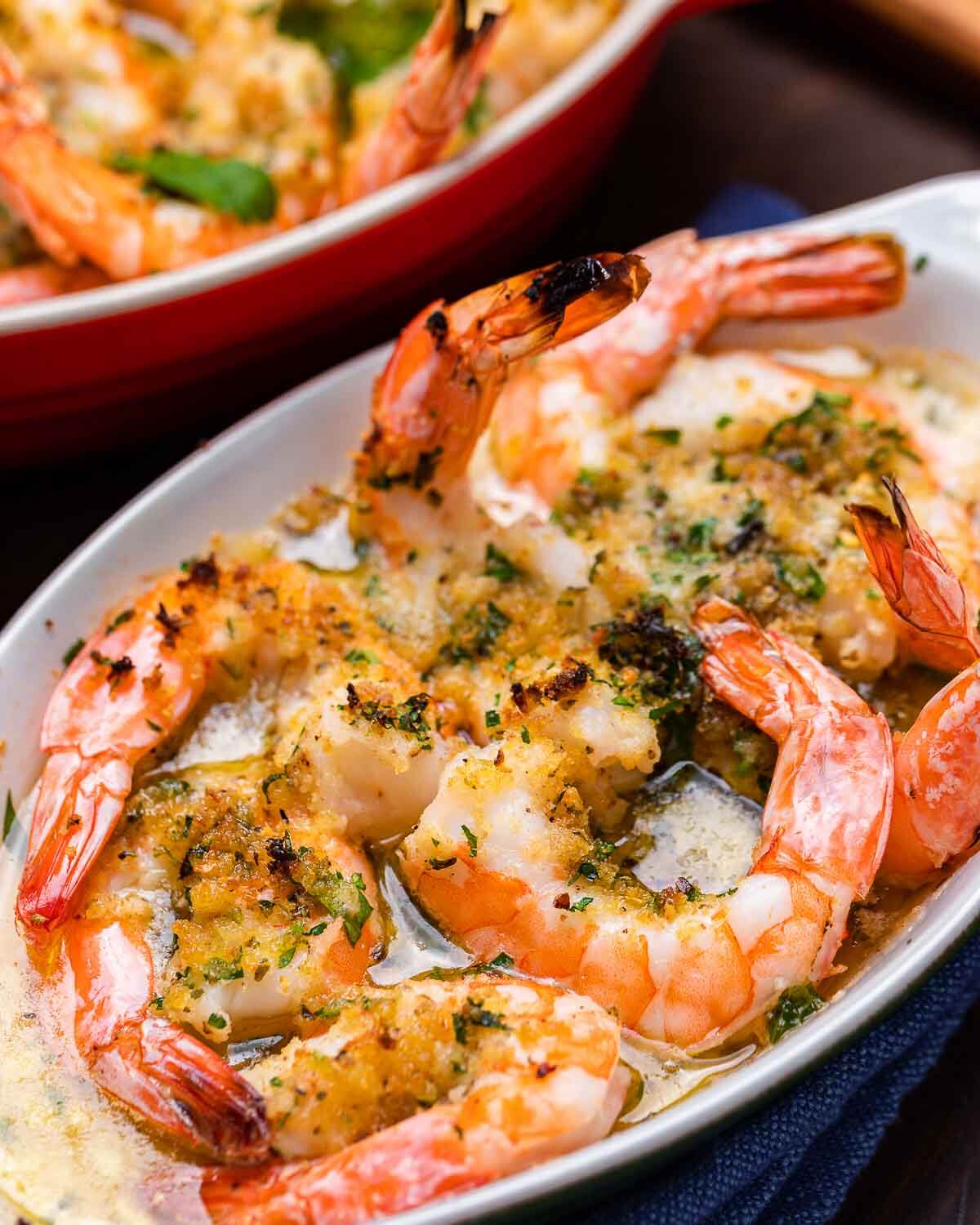 Closeup shot baked shrimp with breadcrumbs in white plate.