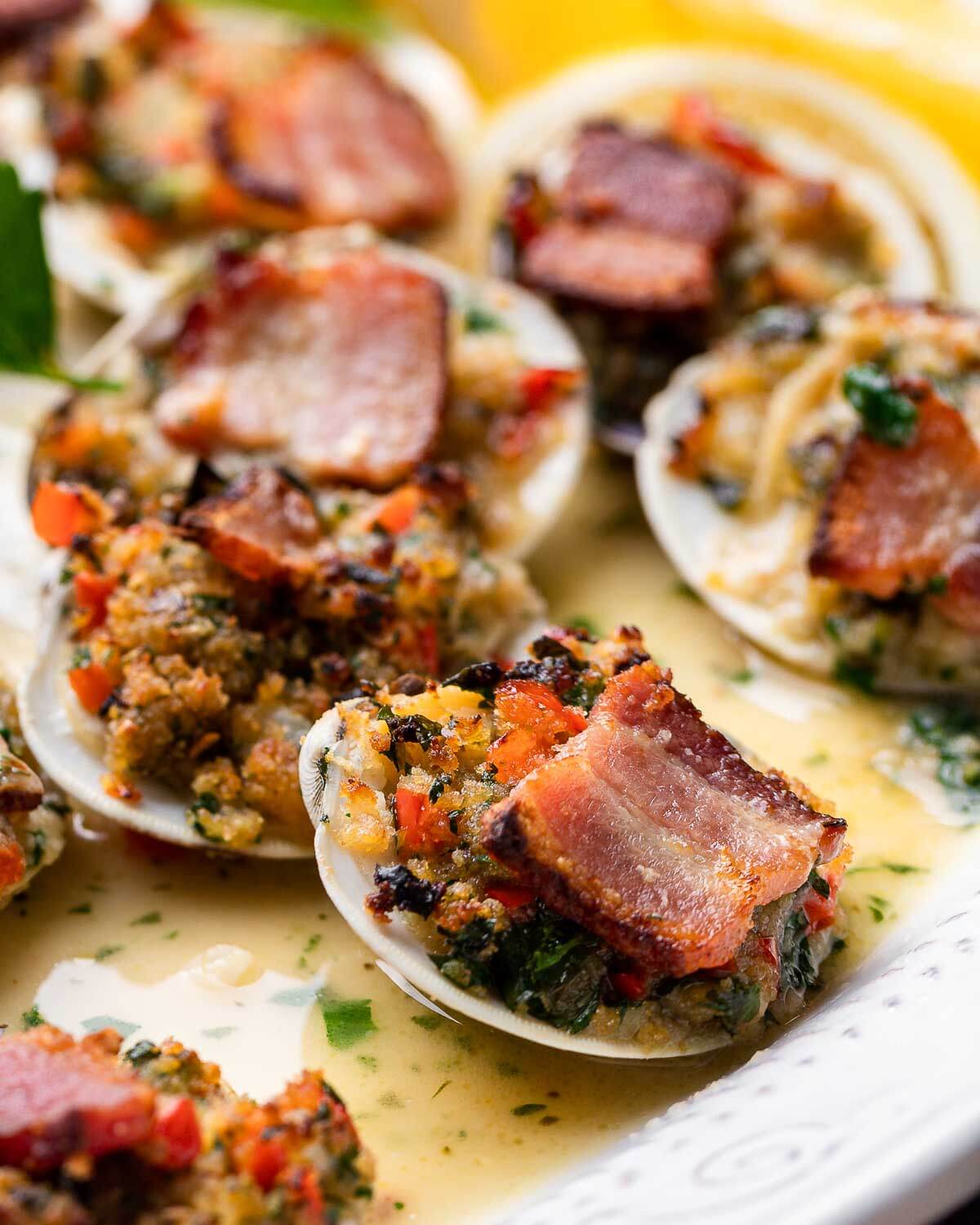Closeup shot of clams casino in white plate.