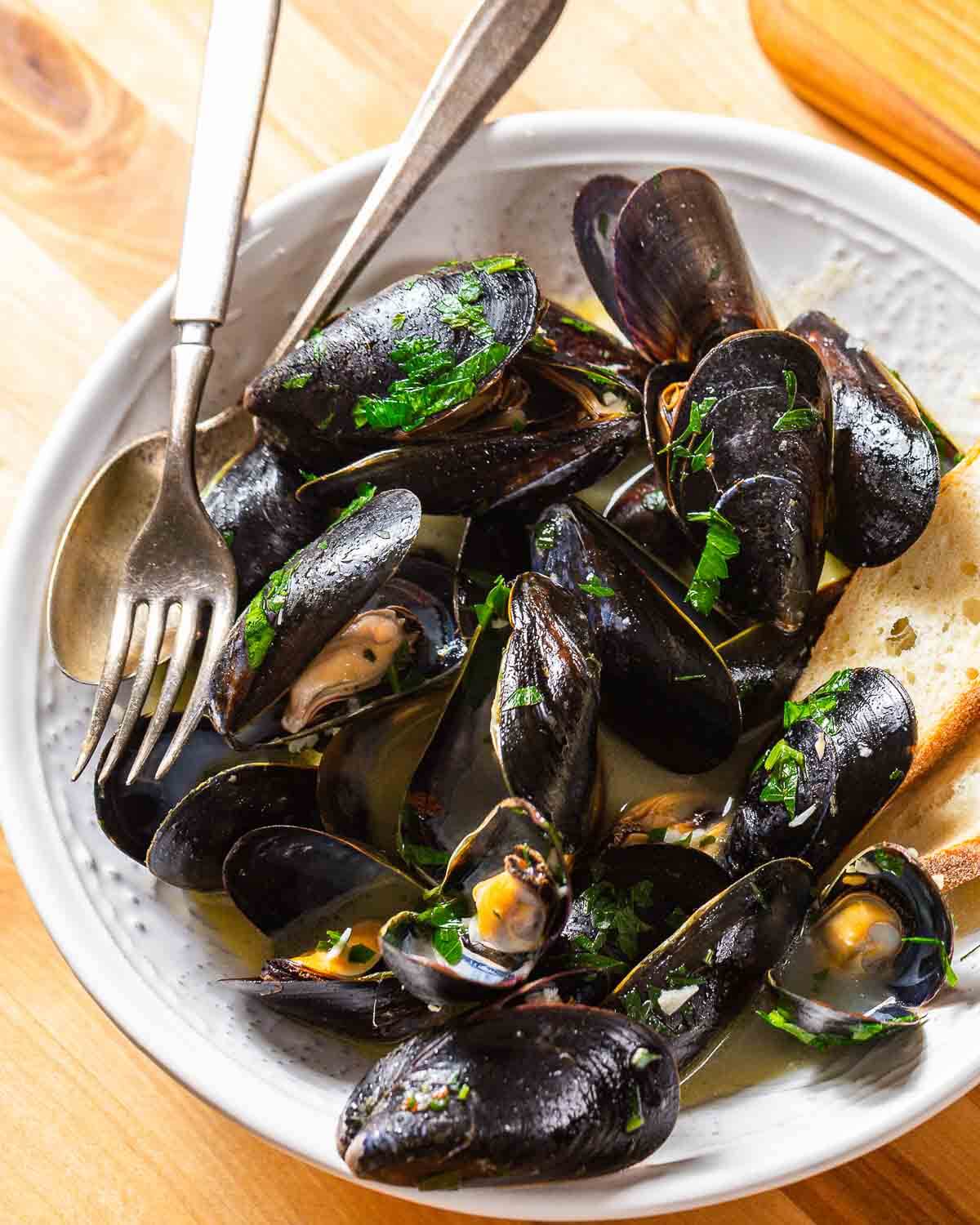 Mussels with white wine sauce in white plate.