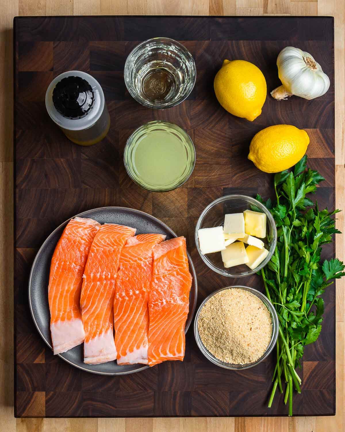 Ingredients shown: olive oil, white wine, chicken stock, lemons, garlic, salmon, butter, breadcrumbs, and parsley.