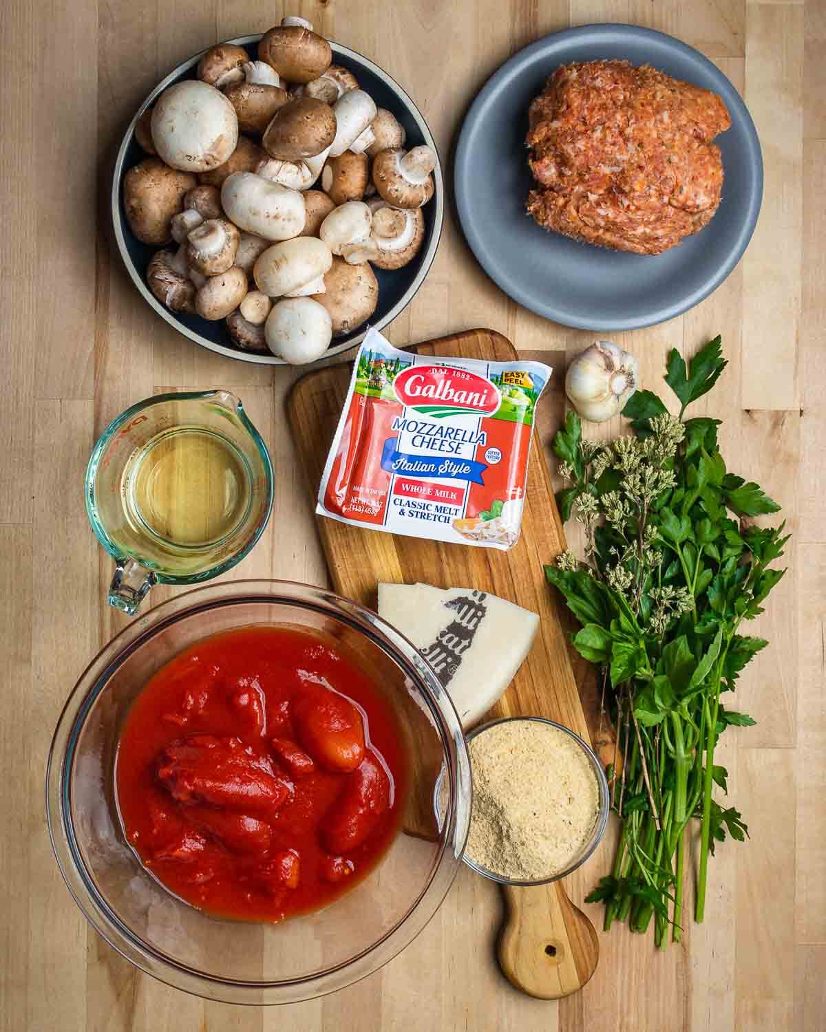 Ingredients shown: mushrooms, sausage, white wine, mozzarella, Pecorino, plum tomatoes, breadcrumbs, garlic and fresh herbs.