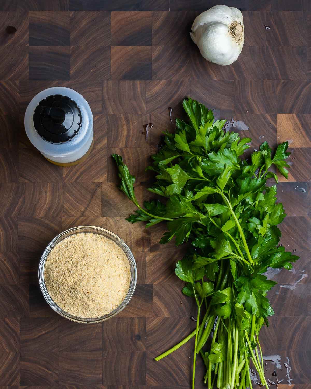 Seasoned breadcrumbs ingredients on walnut cutting board.