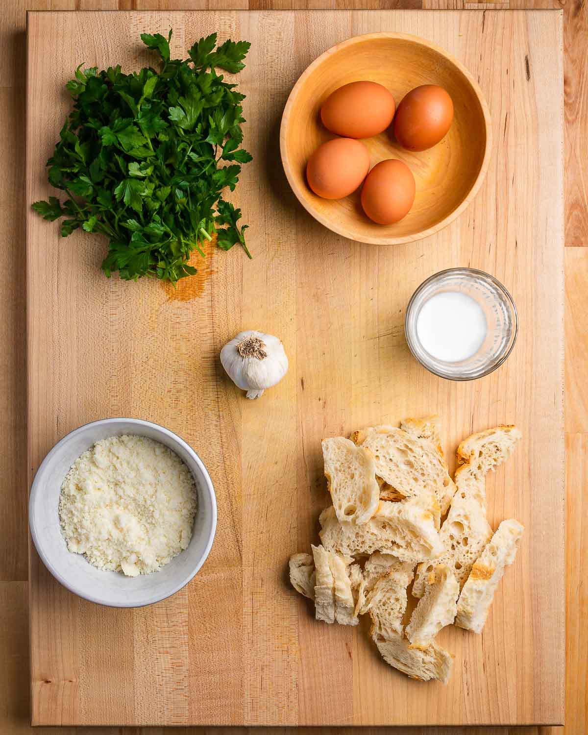 Ingredients shown: parsley, eggs, garlic, milk, Pecorino Romano, and bread.