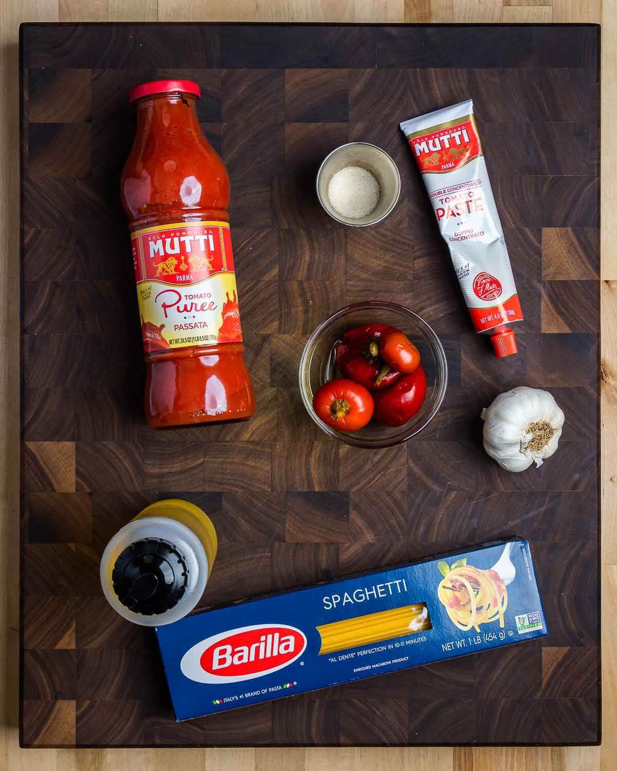 Ingredients shown: passata, sugar, tomato paste, cherry peppers, garlic, olive oil, and spaghetti.