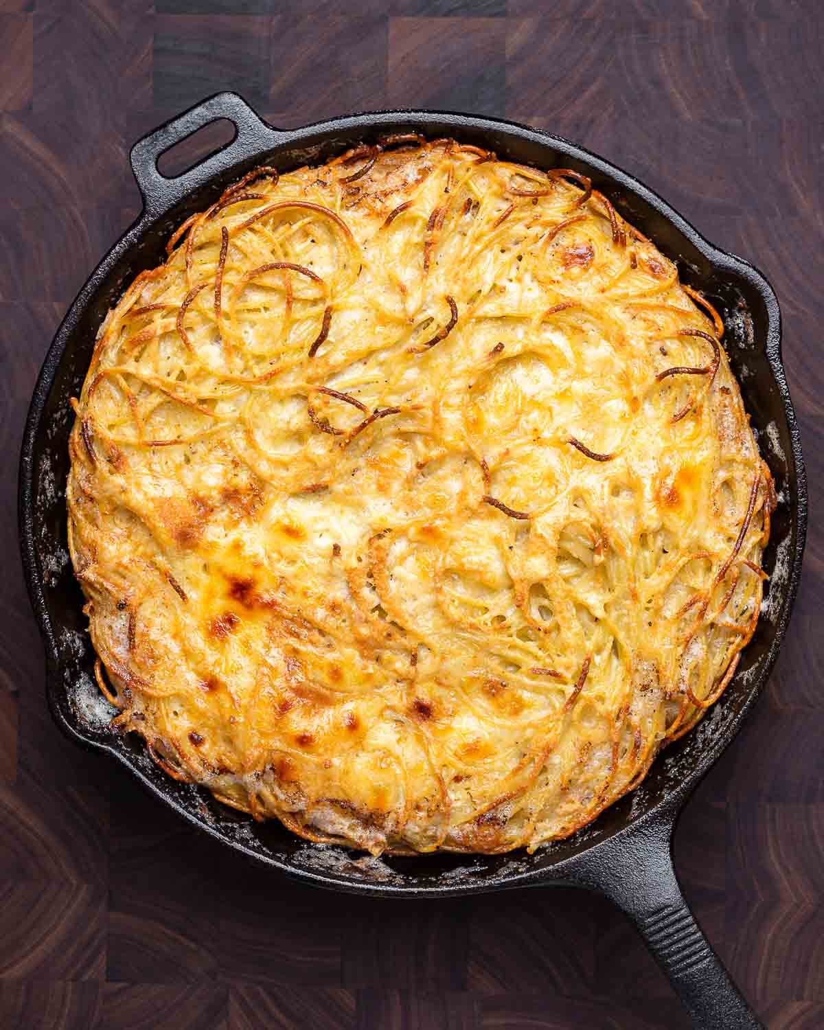 Overhead shot of white spaghetti pie in cast iron pan.