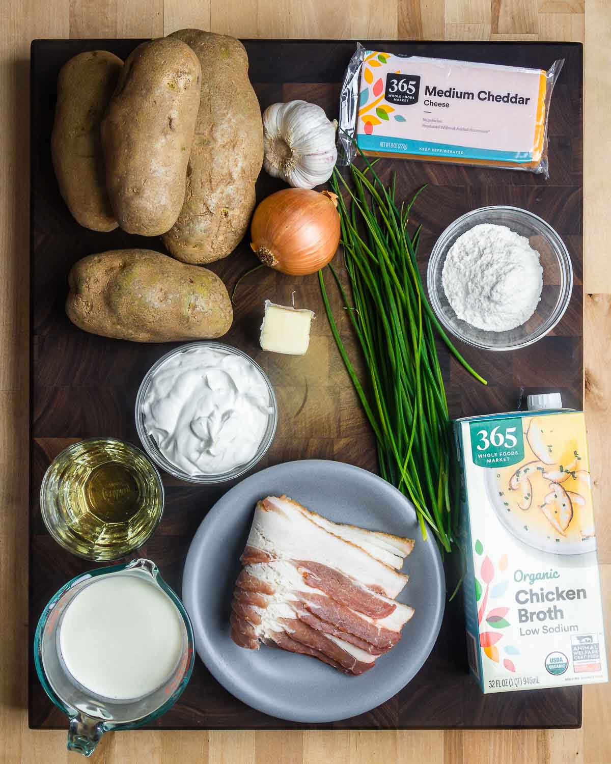 Ingredients shown: potatoes, garlic, onion, cheddar cheese, scallions, flour, wine, sour cream, bacon, cream, and chicken broth.