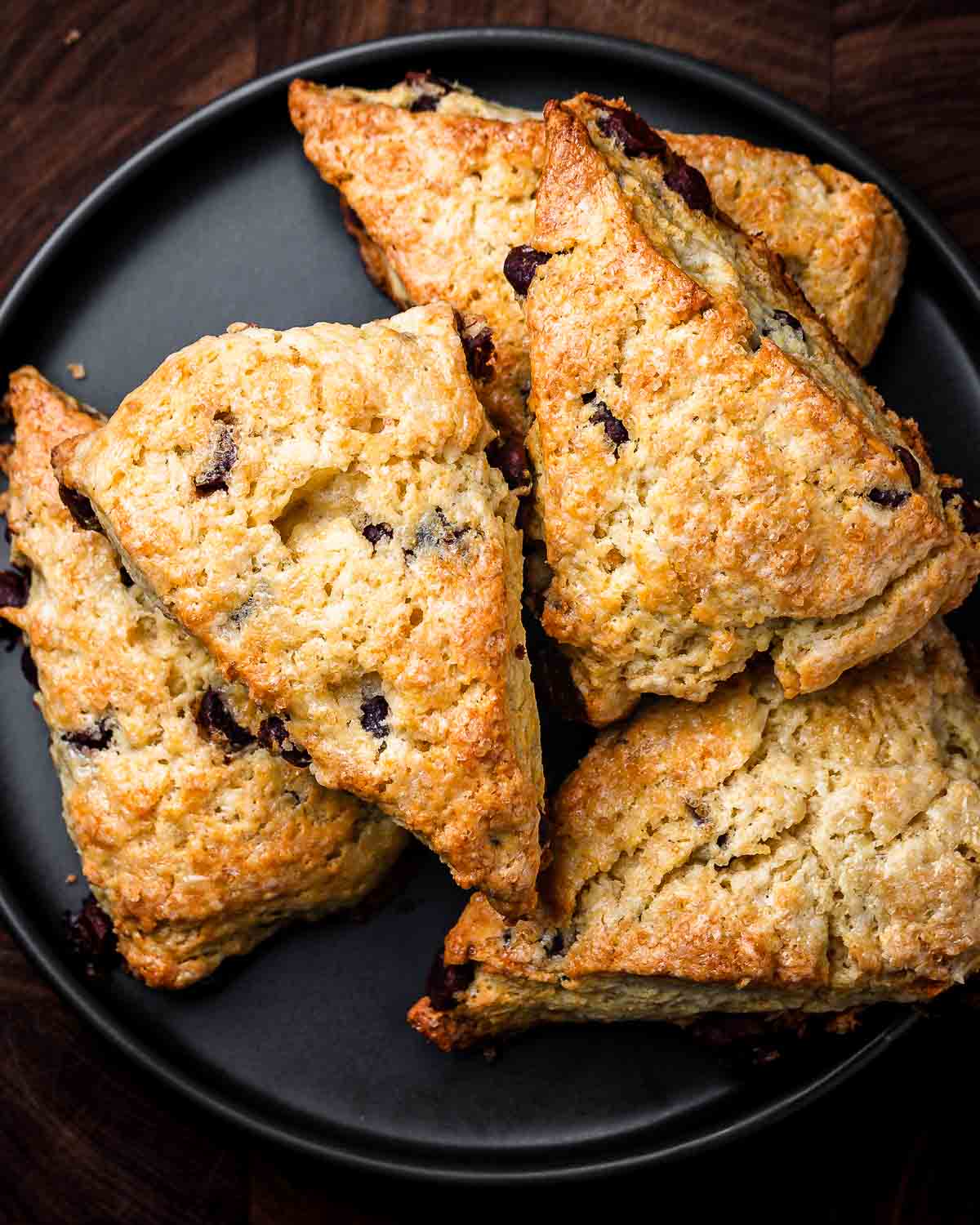 Overhead shot of black plate with chocolate chip scones.