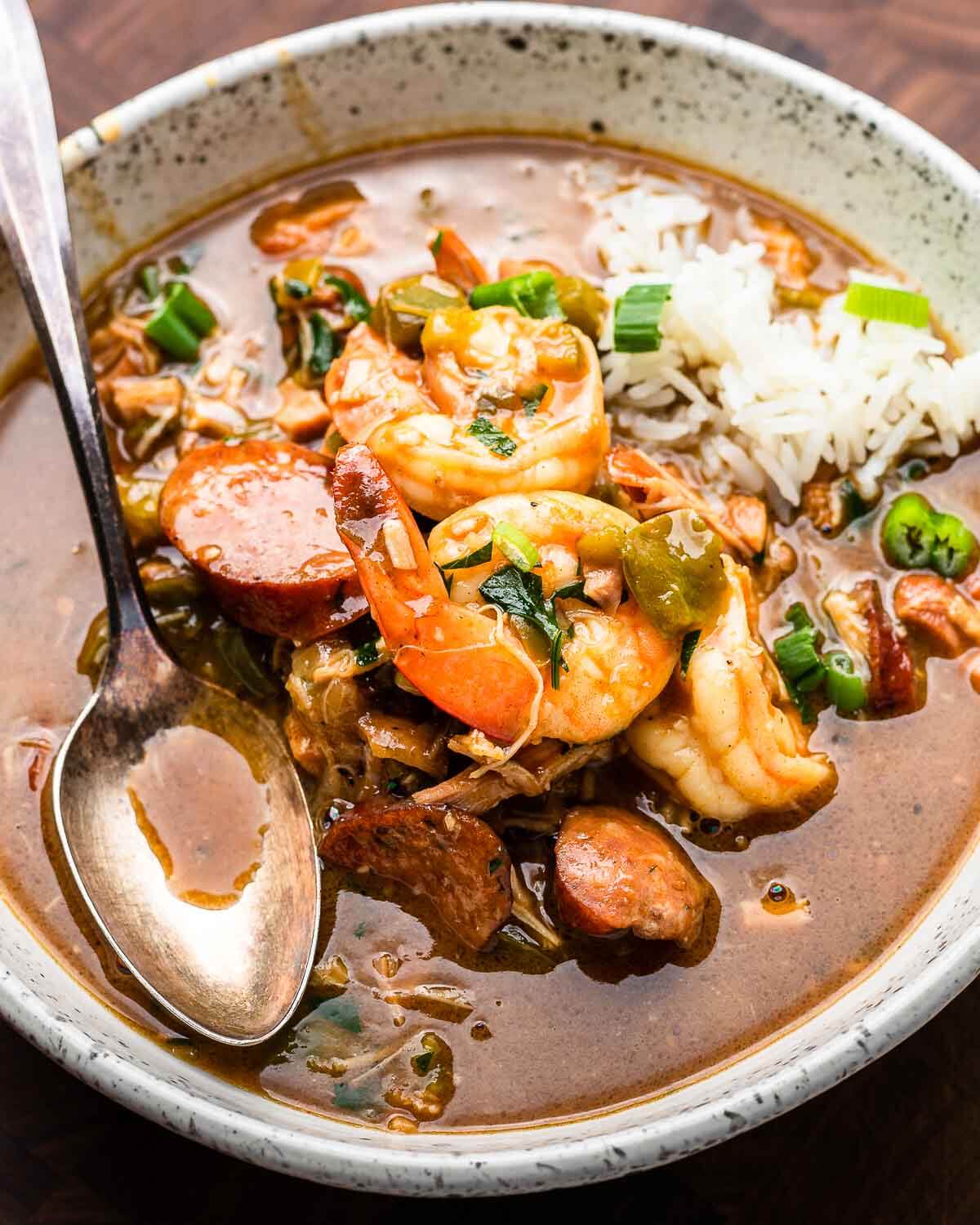 Large white bowl with chicken, sausage, and shrimp gumbo.