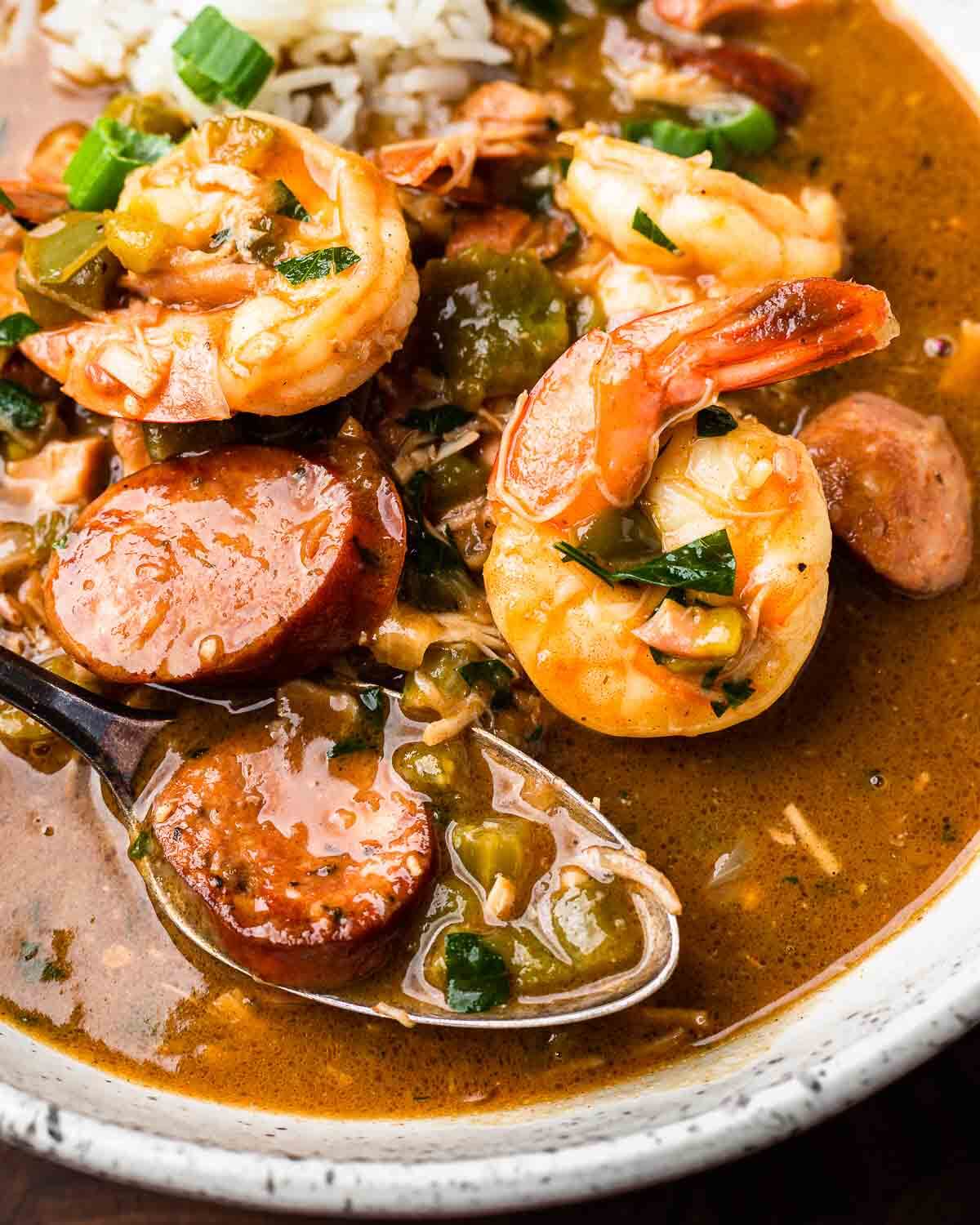 Closeup shot of gumbo in white plate.