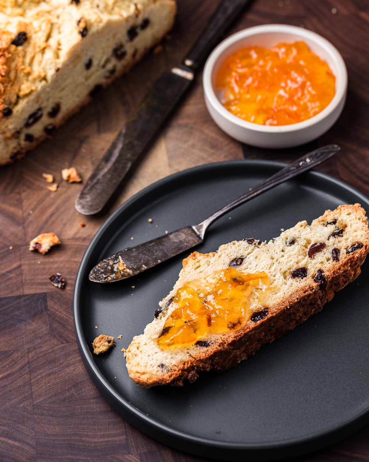 Grey plate with slice of Irish soda bread with orange marmalade.