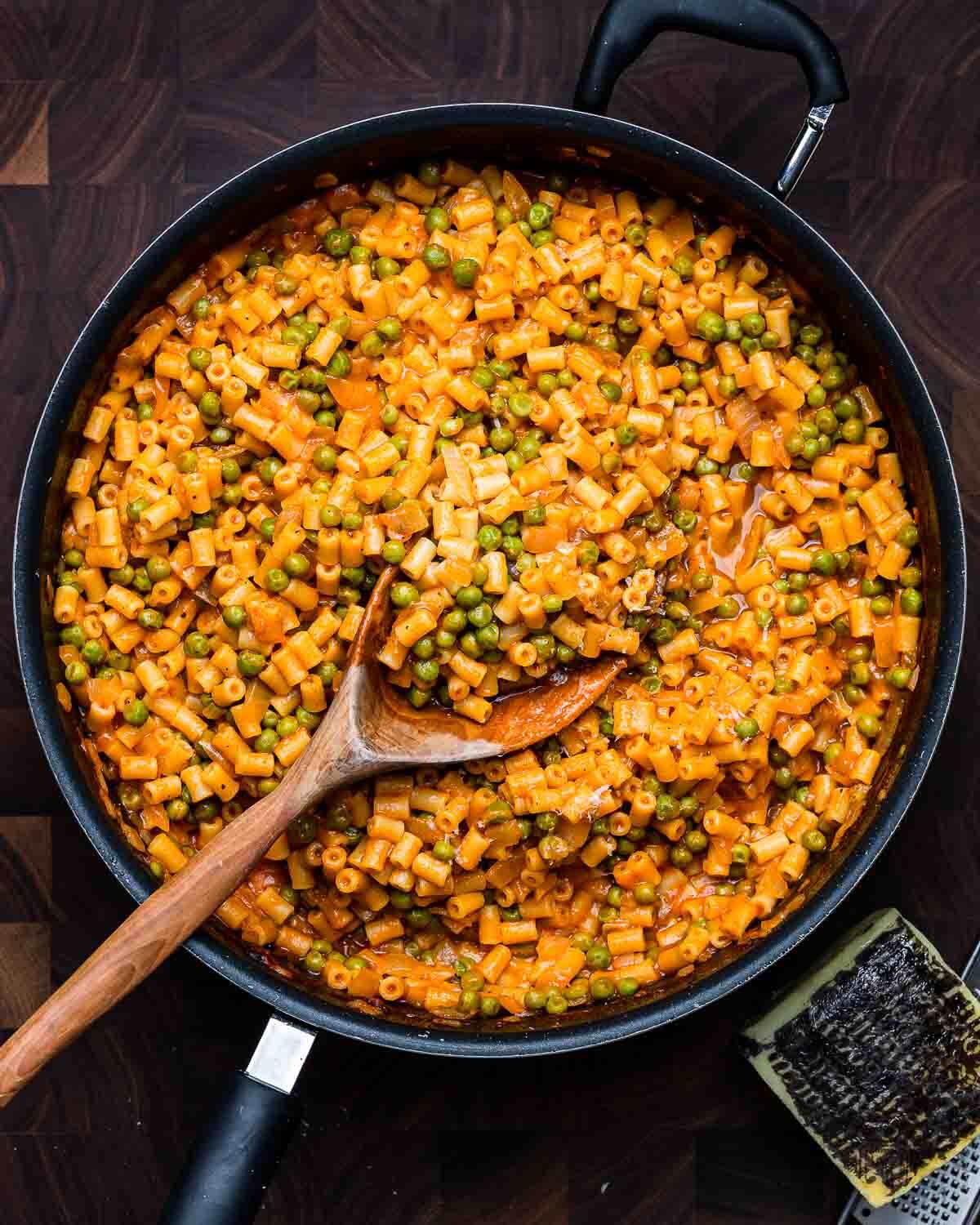 Overhead shot of pasta and peas rosso in large pan.