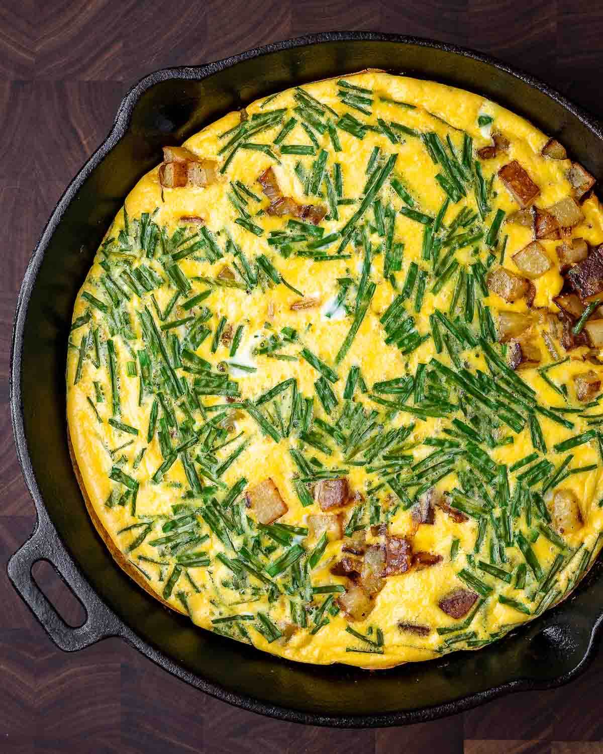 Overhead shot of potato frittata in cast iron pan.