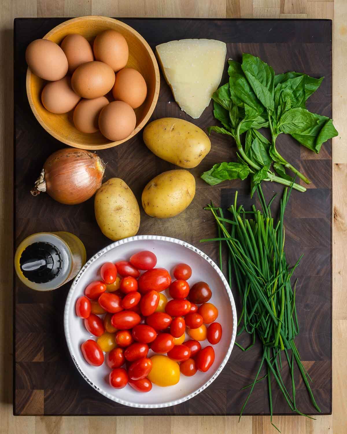 Ingredients shown: eggs, Pecorino Romano, basil, onion, potatoes, chives, olive oil, and potatoes.