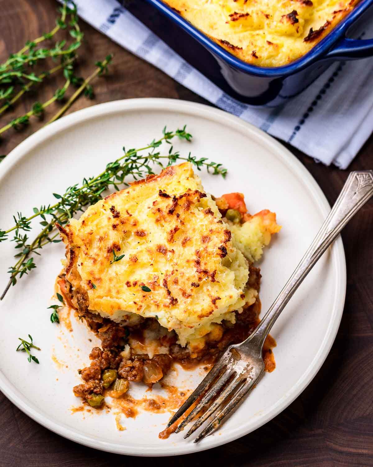 Shepherd's pie in white dish with baking dish in the background.