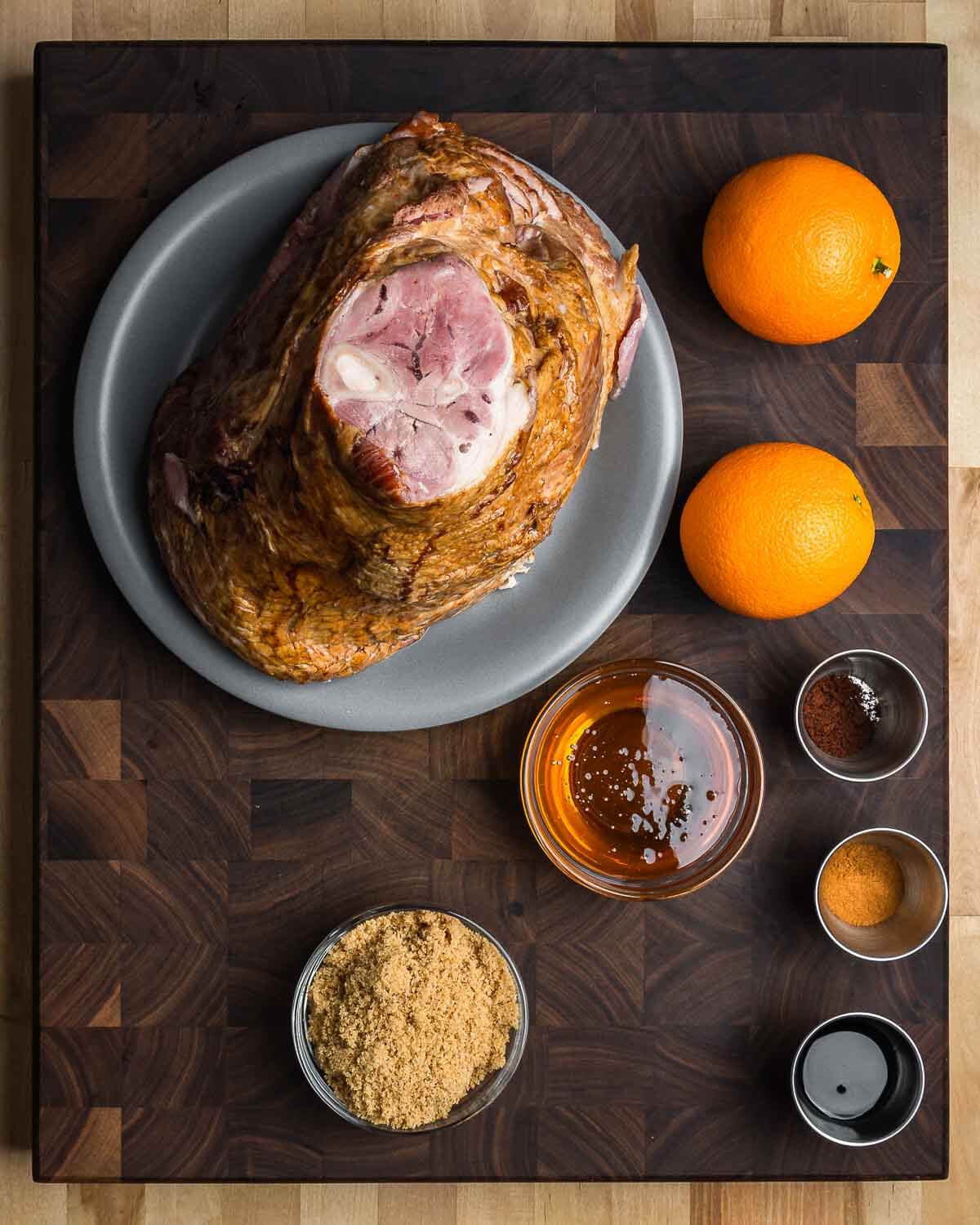 Ingredients shown: spiral ham, oranges, honey, cloves, cinnamon, soy sauce, and brown sugar.