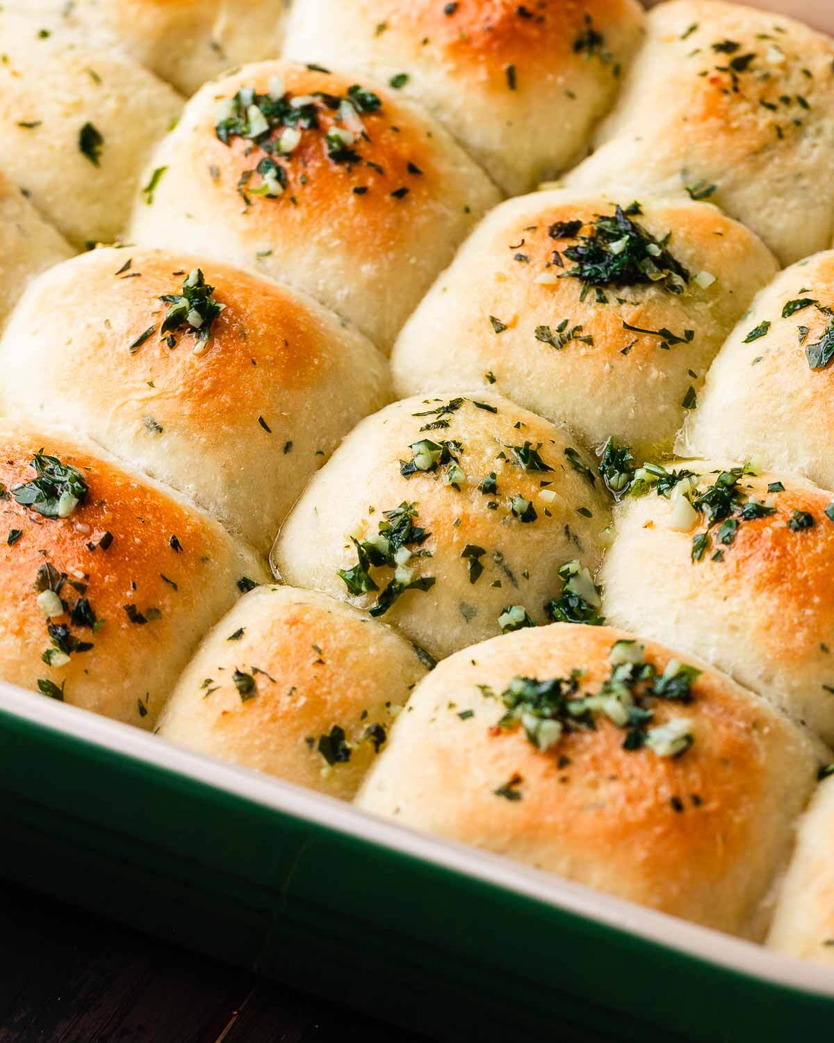 Closeup shot of baking dish with garlic butter dinner rolls.