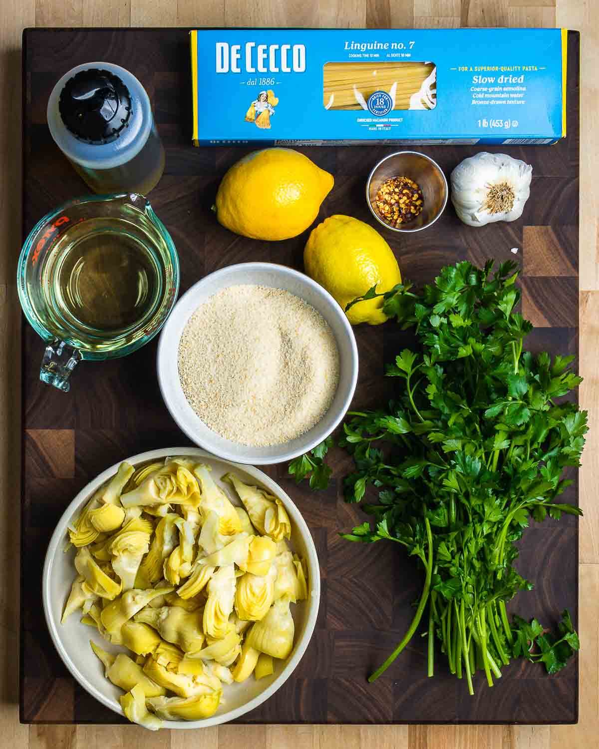 Ingredients shown: linguine, olive oil, lemons, white wine, parsley, garlic, breadcrumbs, and artichoke hearts.