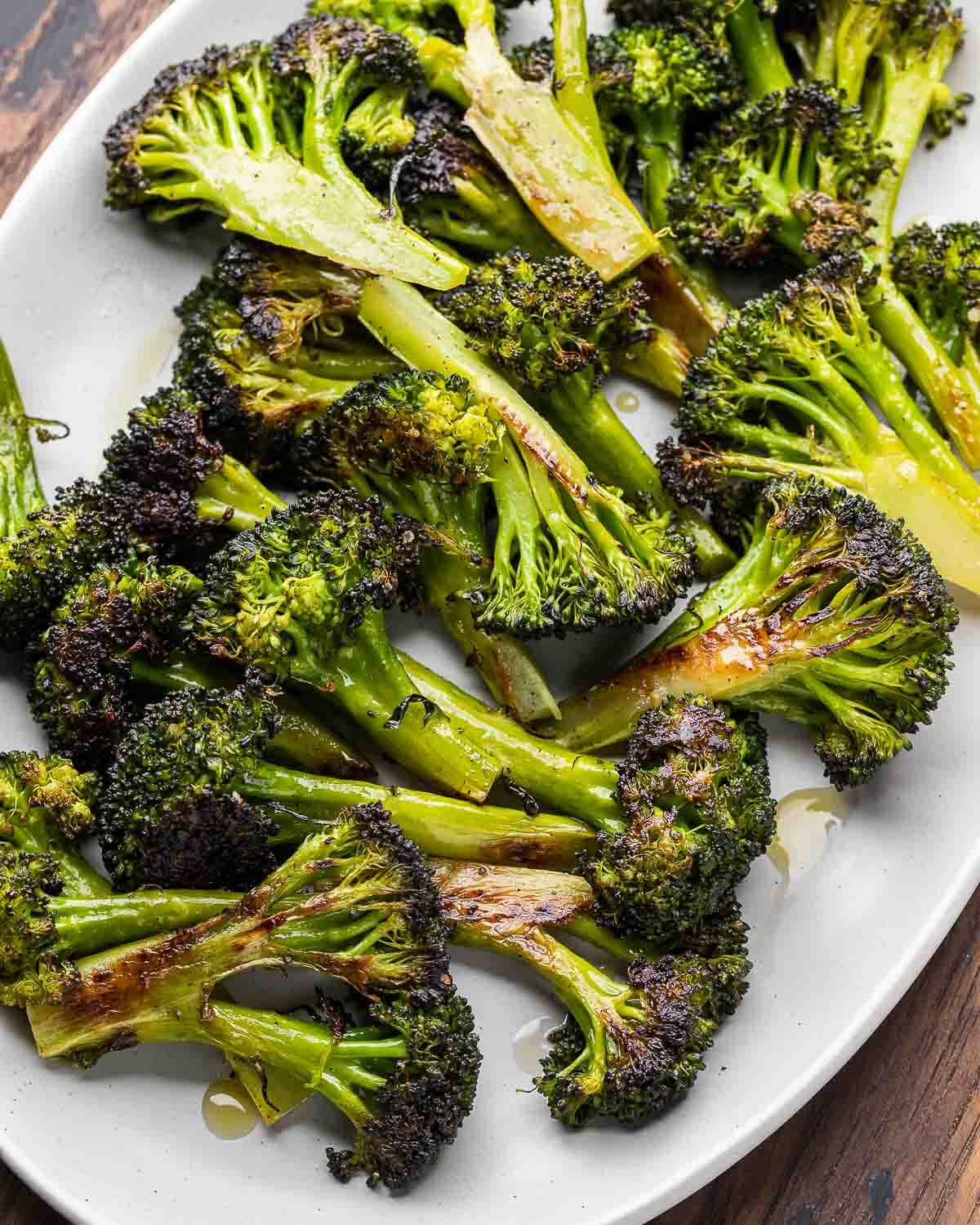 Overhead shot of roasted broccoli in grey platter.