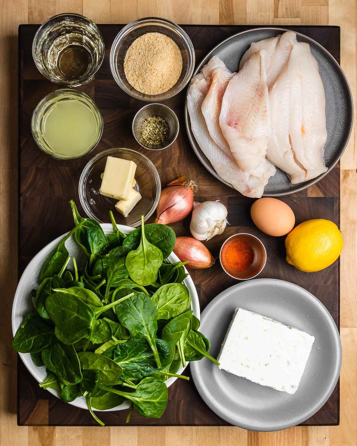 Ingredients shown: white wine, chicken stock, breadcrumbs, oregano, flounder, butter, shallots, garlic, paprika, egg, lemon, baby spinach, and feta cheese.