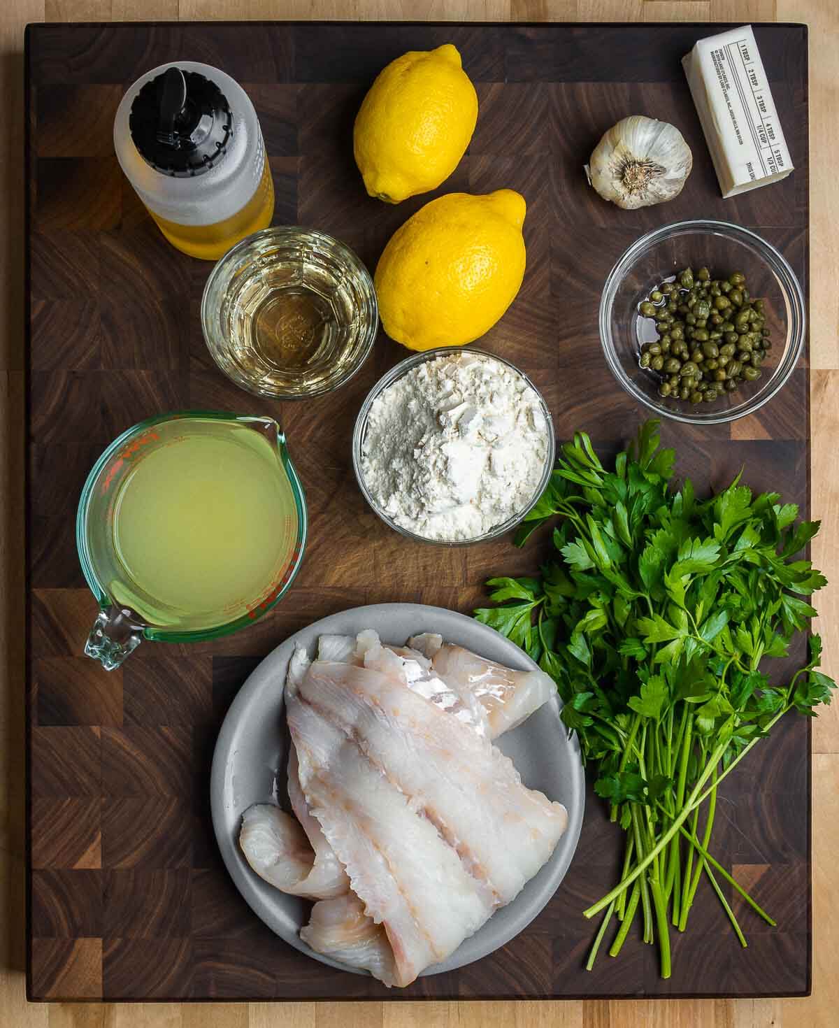 Ingredients shown: olive oil, white wine, lemons, garlic, butter, capers, chicken stock, flour, cod, and parsley.