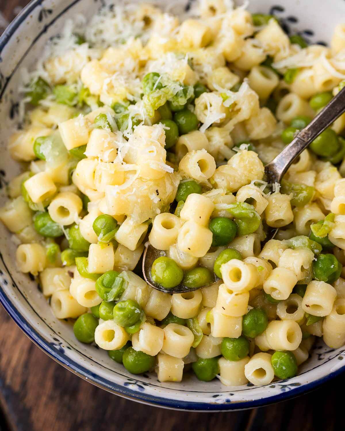 Closeup shot of blue and white bowl with pasta e piselli.