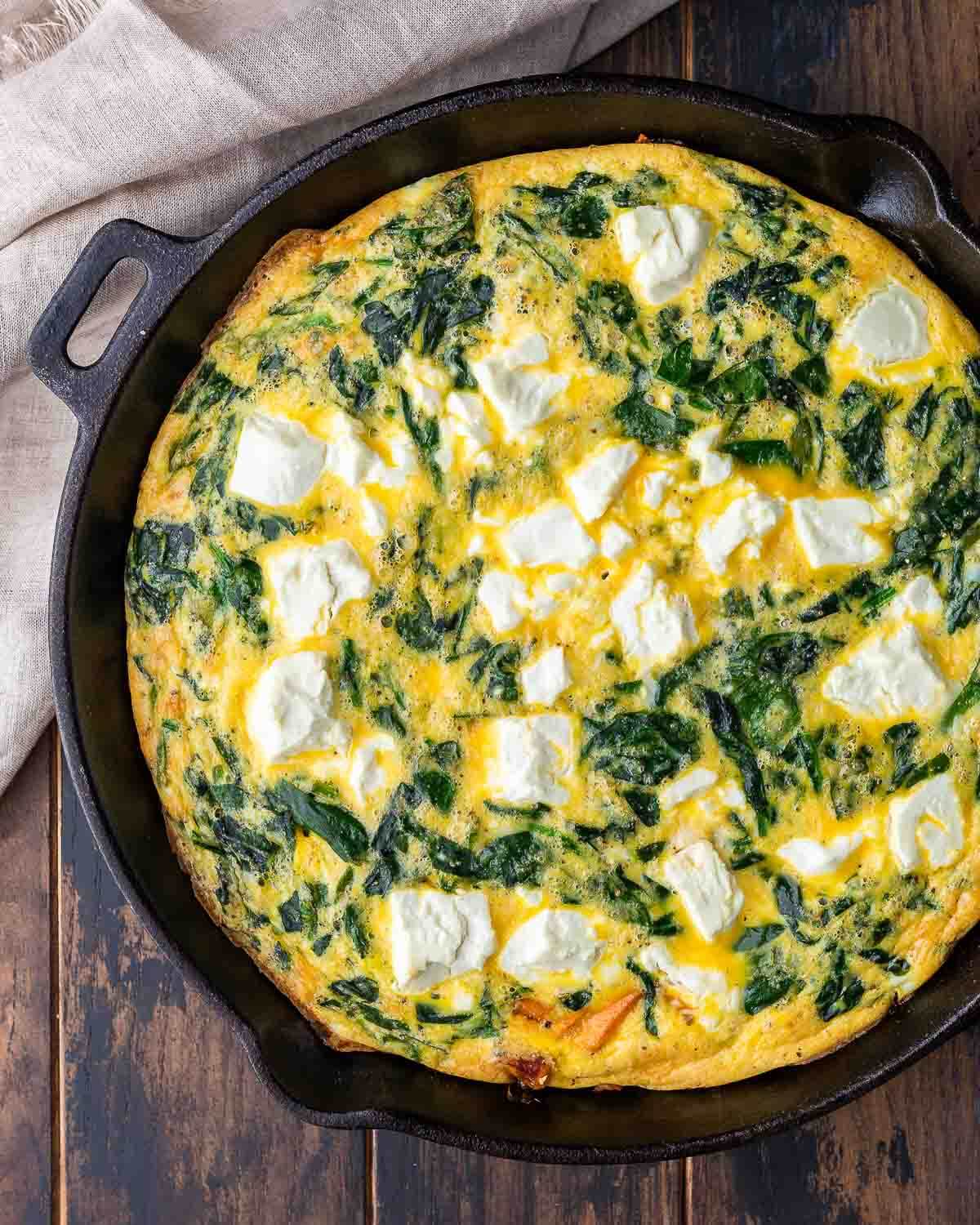 Overhead shot of sweet potato and goat cheese frittata in cast iron pan.