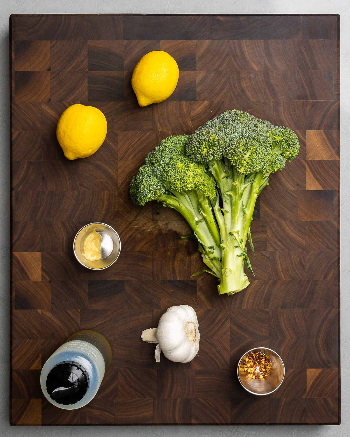 Ingredients shown: lemons, broccoli, Dijon mustard, extra virgin olive oil, garlic, and hot red pepper flakes.