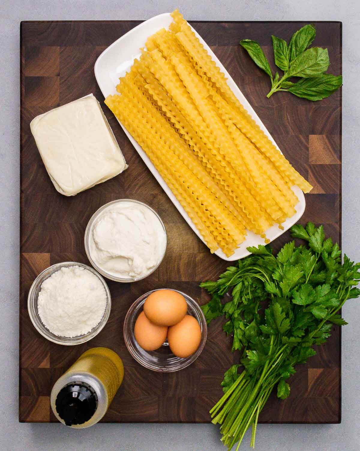 Ingredients shown: mozzarella, mafaldine, basil, ricotta, Pecorino, olive oil, eggs, and parsley.