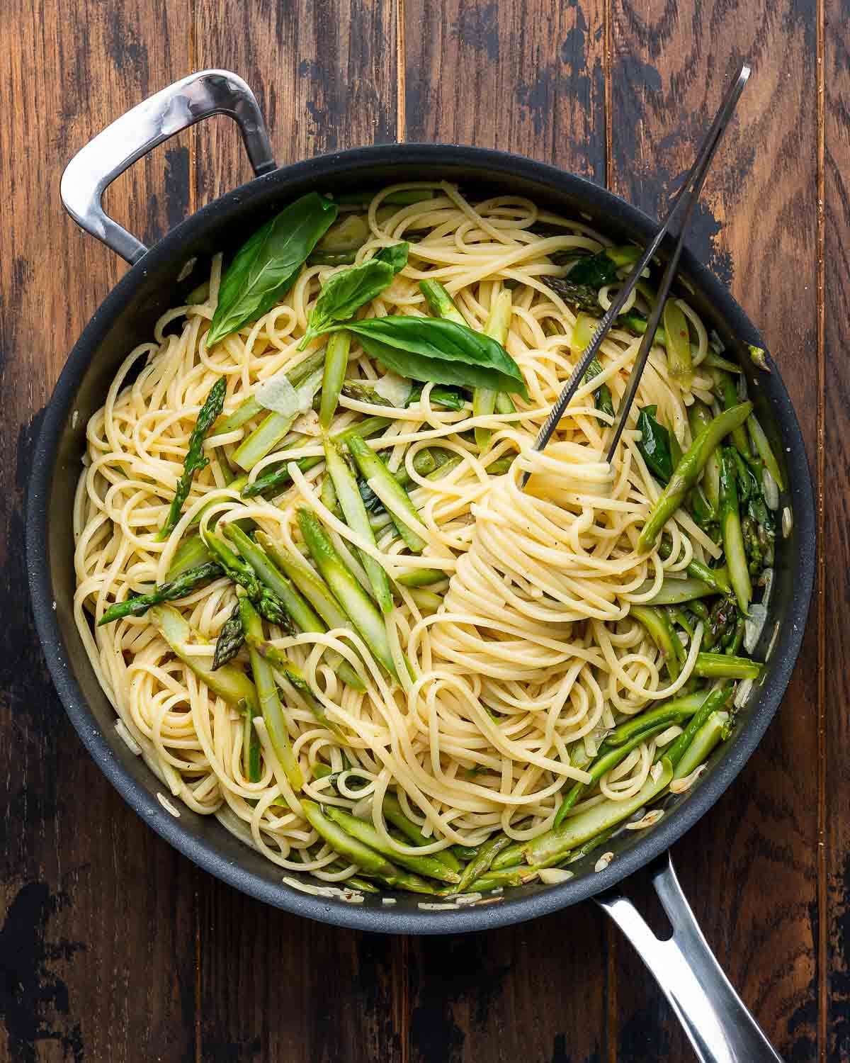 Overhead shot of lemon asparagus pasta on wooden board.