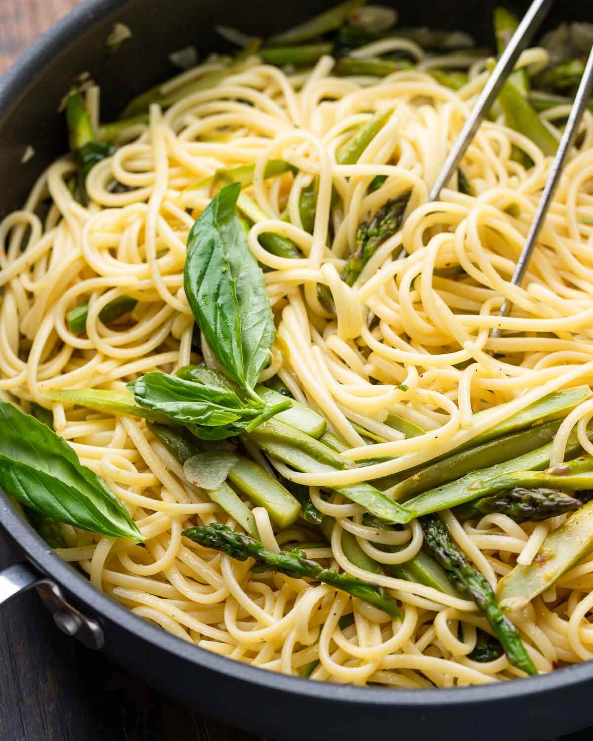 Closeup shot of lemon basil asparagus pasta in black pan.