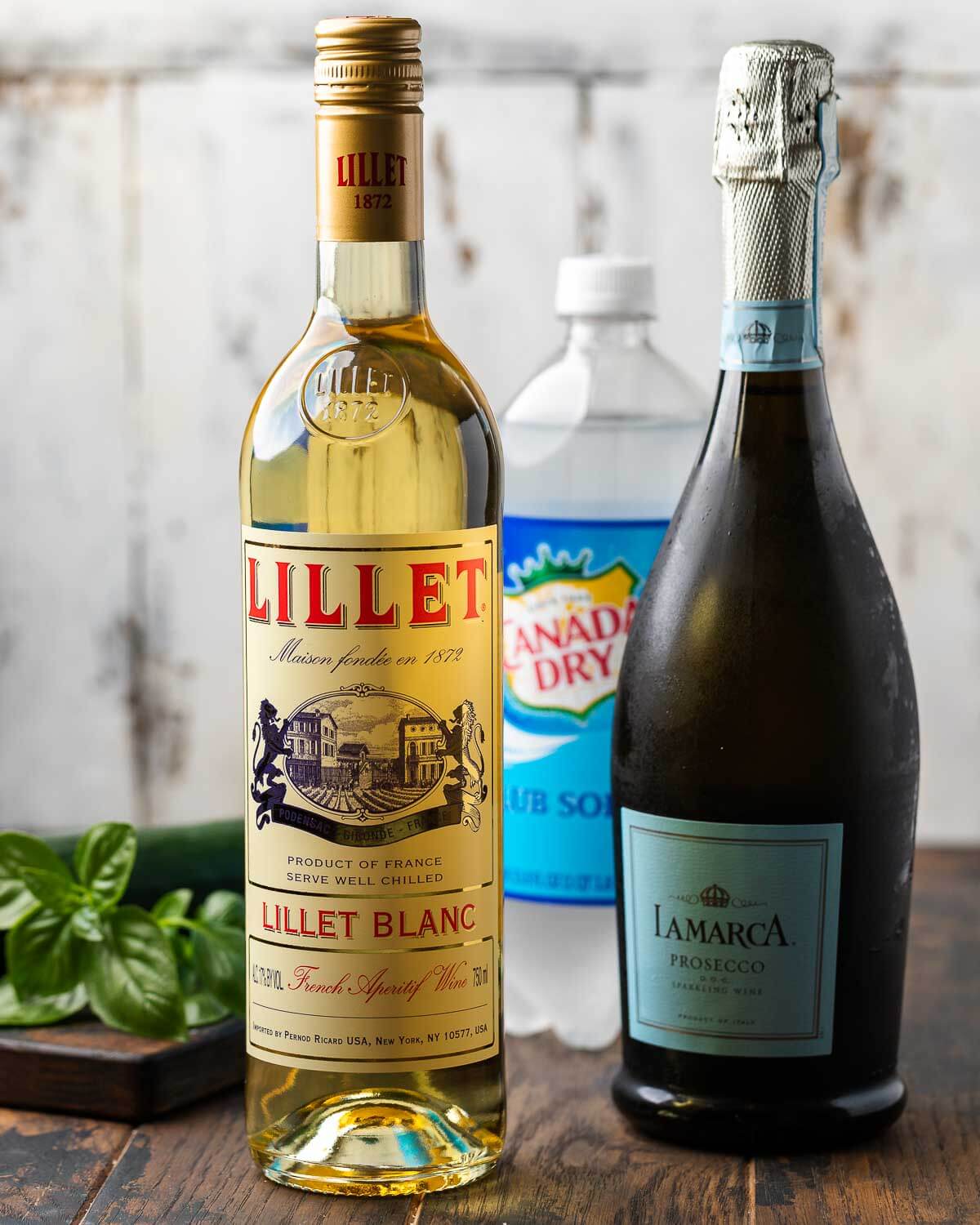Ingredients shown: Lillet blanc, prosecco, club soda, basil, and cucumber.