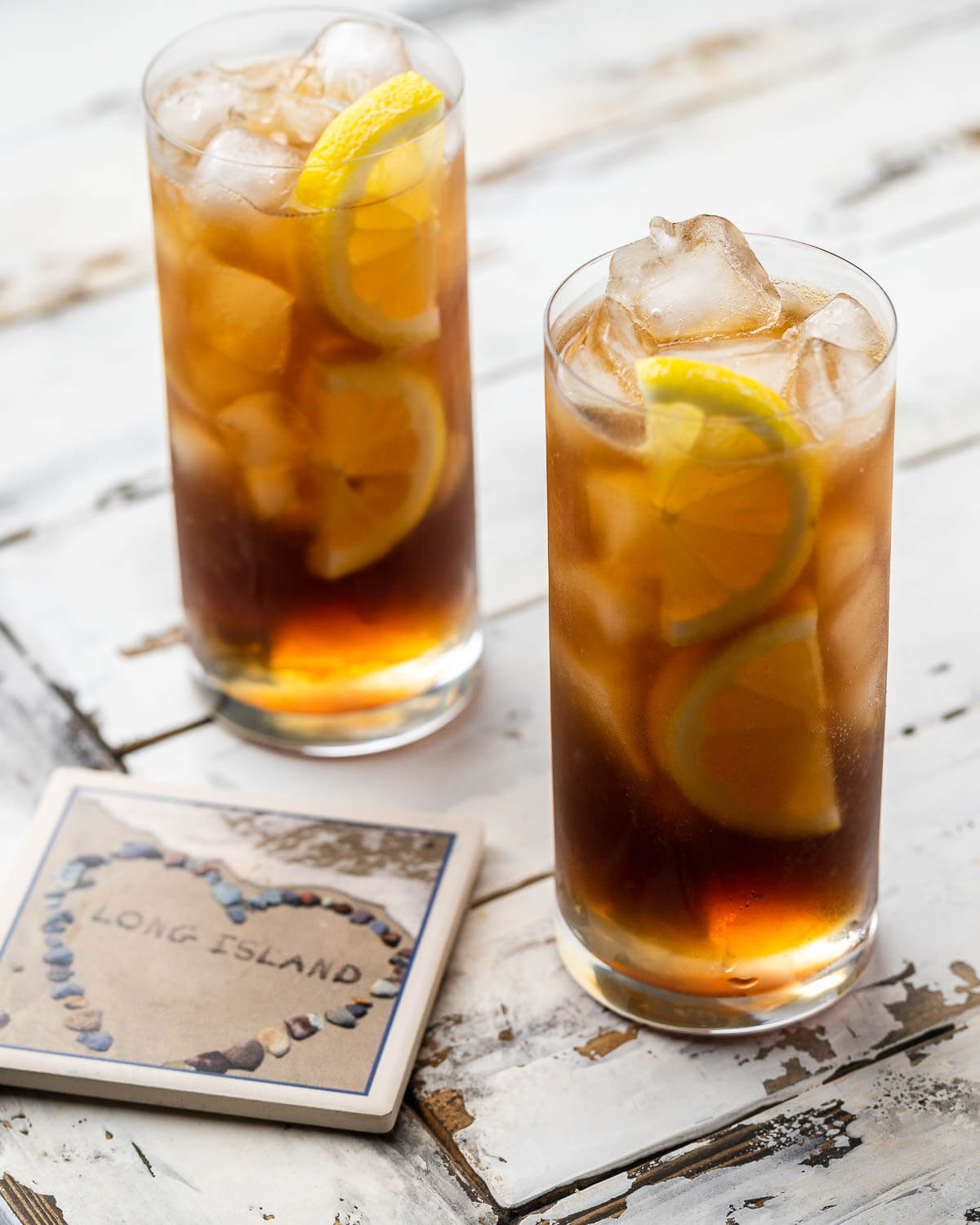 Two glasses of Long Island iced tea along with coaster of Long Island.
