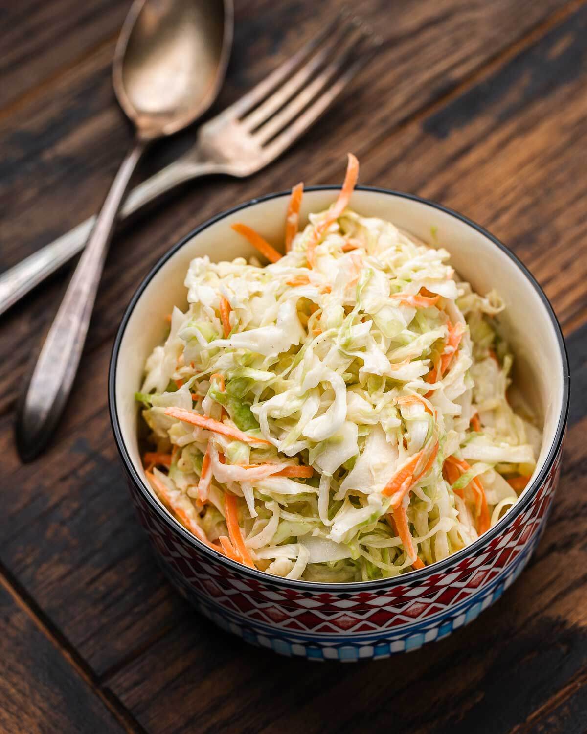 Small bowl of New York deli coleslaw on wood table.