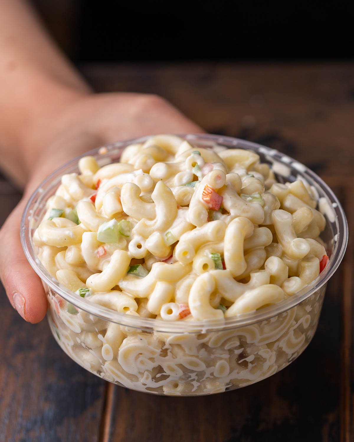 Hands holding container of homemade NY deli macaroni salad.