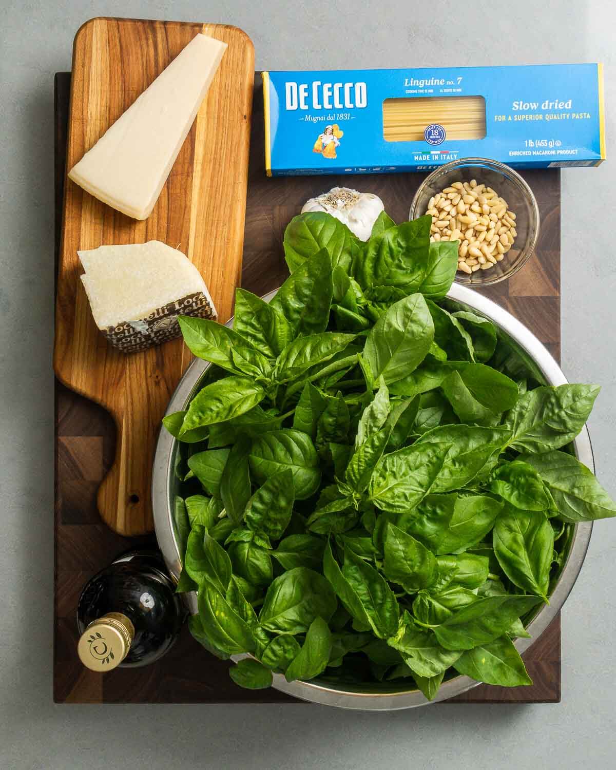 Ingredients shown: Pecorino Romano, Parmigiano Reggiano, linguine, garlic, pine nuts, basil, and extra virgin olive oil.