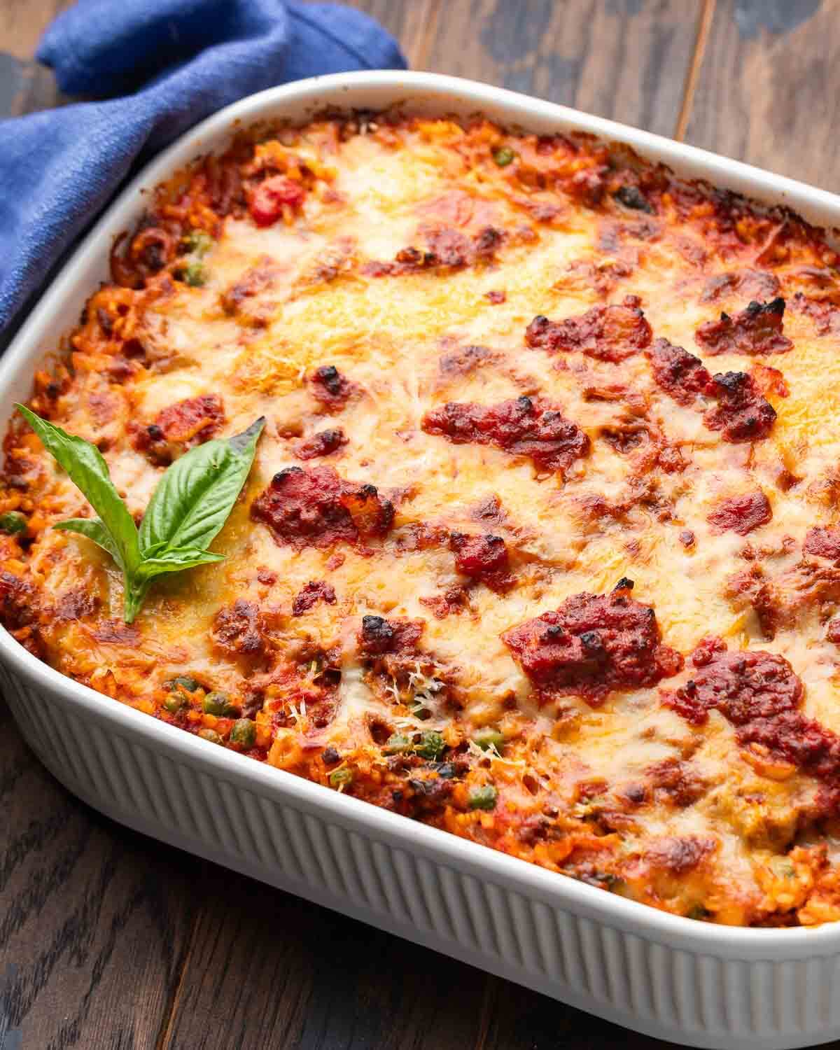 Large baking dish with riso al forno on wooden board.