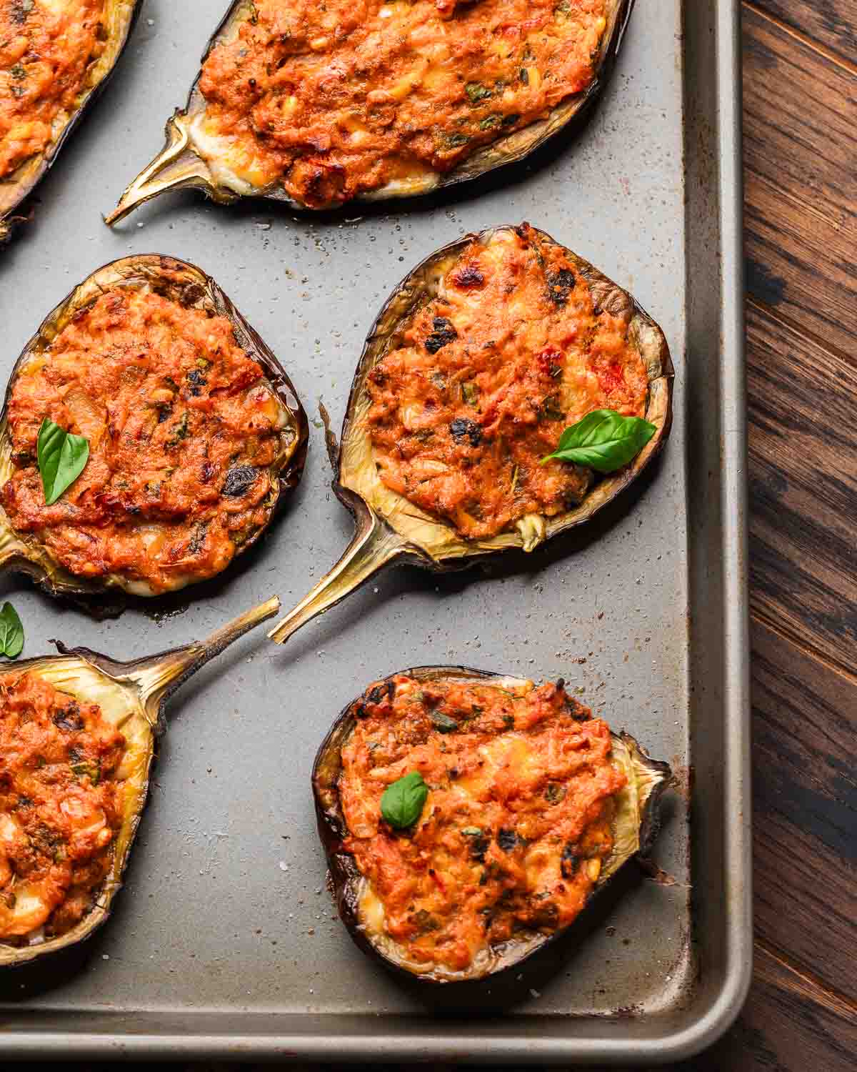 Overhead shot of baking tray with stuffed eggplant.