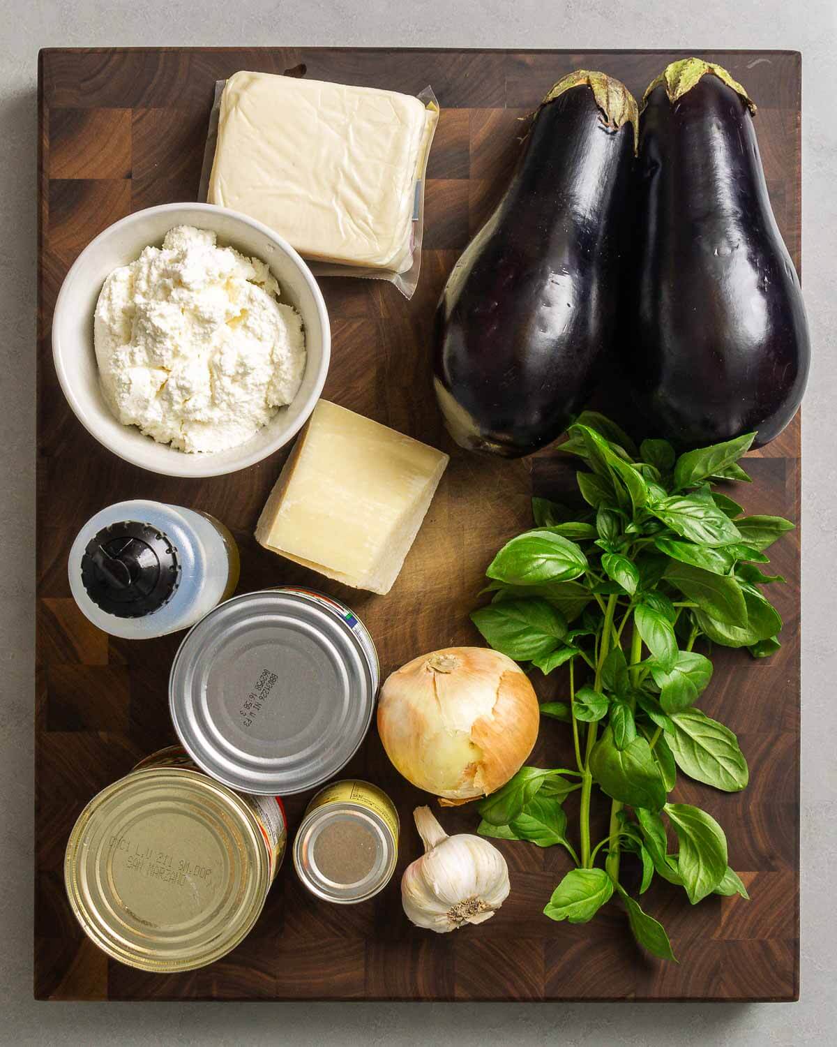 Ingredients shown: mozzarella, ricotta, eggplant, Pecorino, olive oil, canned tomatoes, tomato paste, onion, garlic, and basil.