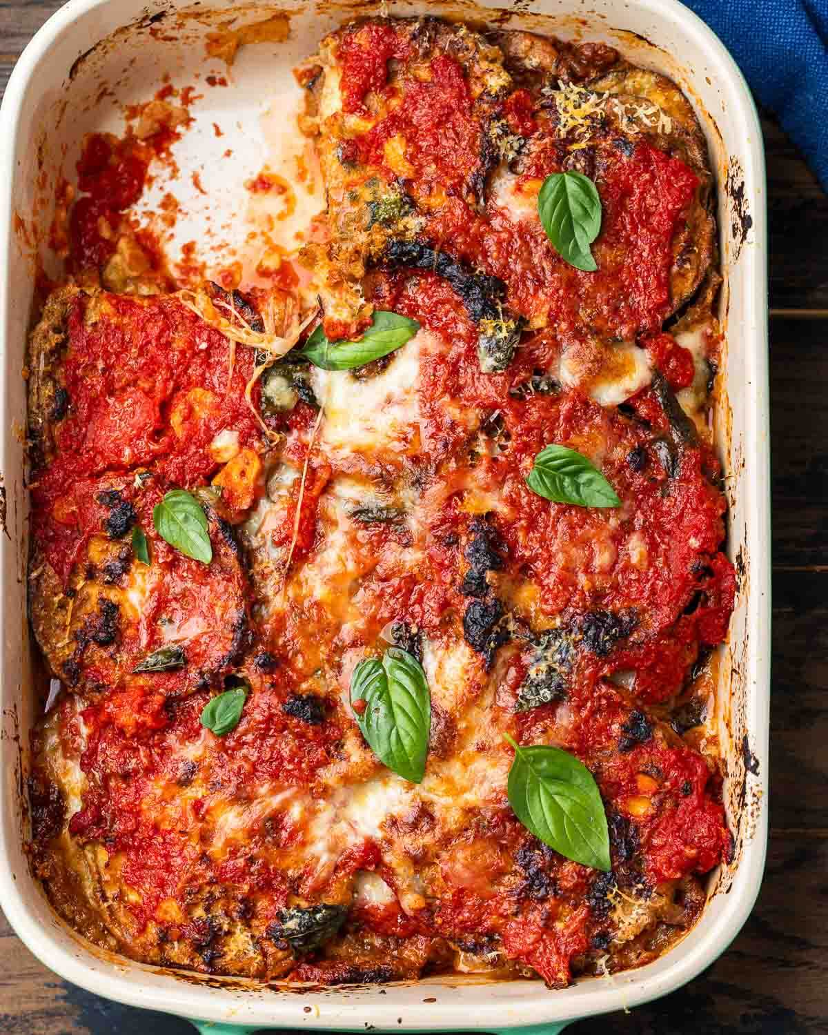 Overhead shot of Neapolitan style eggplant parmigiana in baking dish.