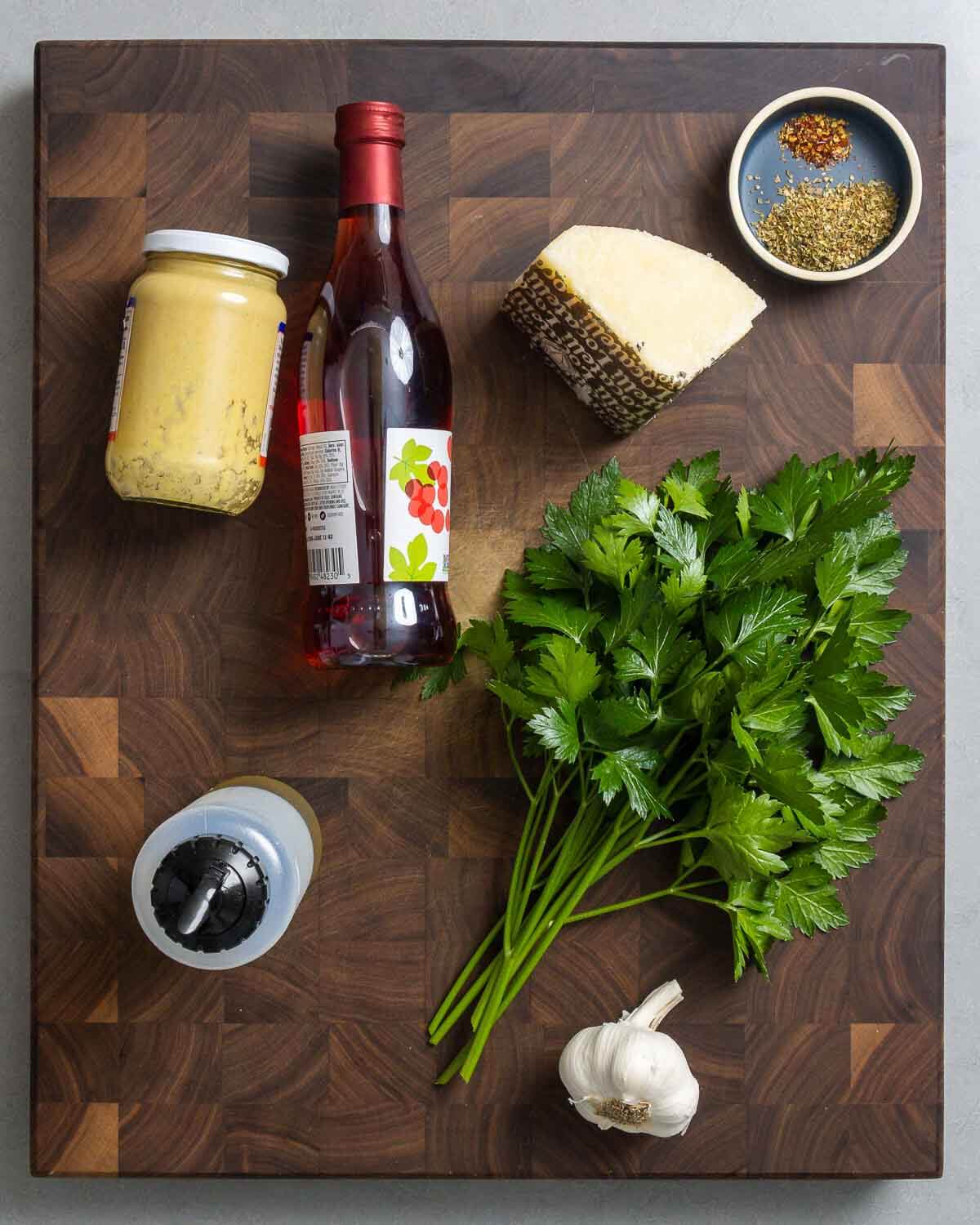 Ingredients shown: Dijon mustard, red wine vinegar, Pecorino, oregano, hot red pepper flakes, extra virgin olive oil, parsley, and garlic.