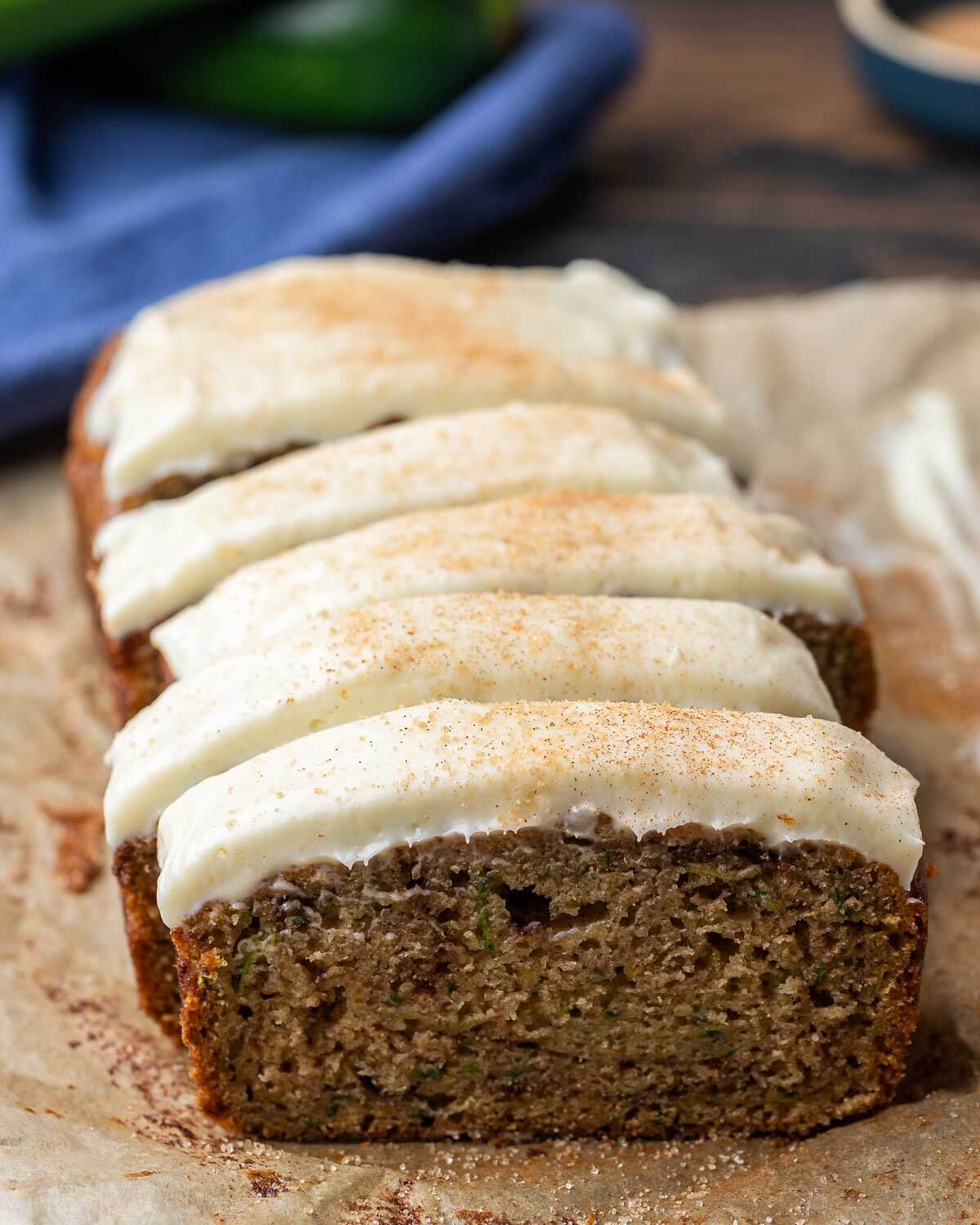 Closeup shot of cut zucchini bread with cream cheese frosting.