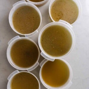 Multiple containers of chicken stock on counter.