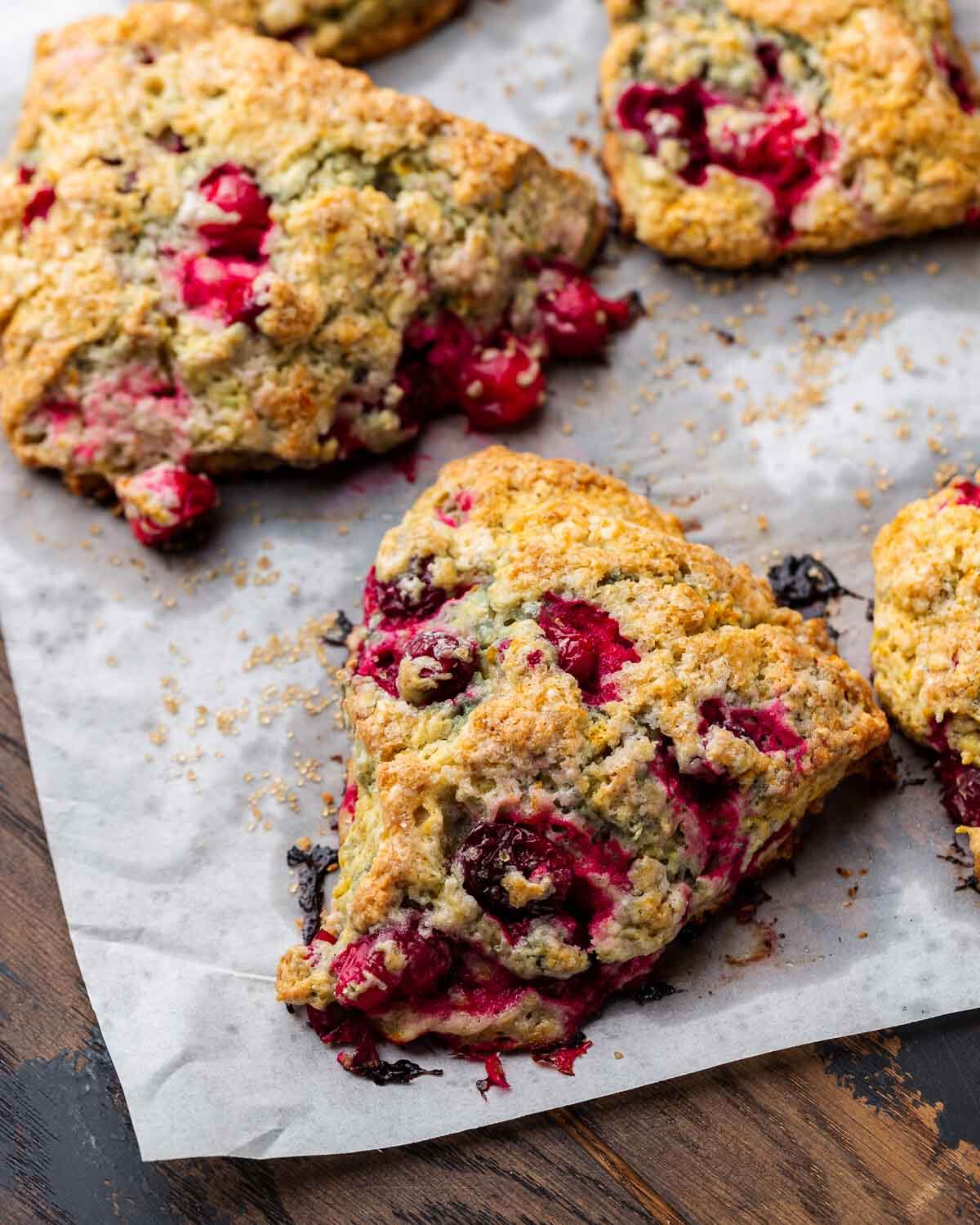 Cranberry orange scones on top of parchment paper.