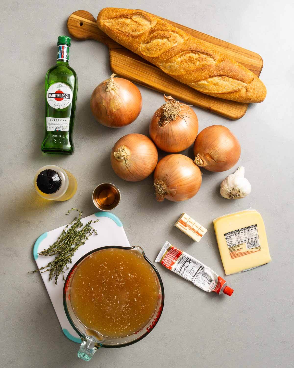 Ingredients shown: vermouth, baguette, onions, olive oil, brandy, butter, garlic, tomato paste, gruyere cheese, thyme, and beef stock.