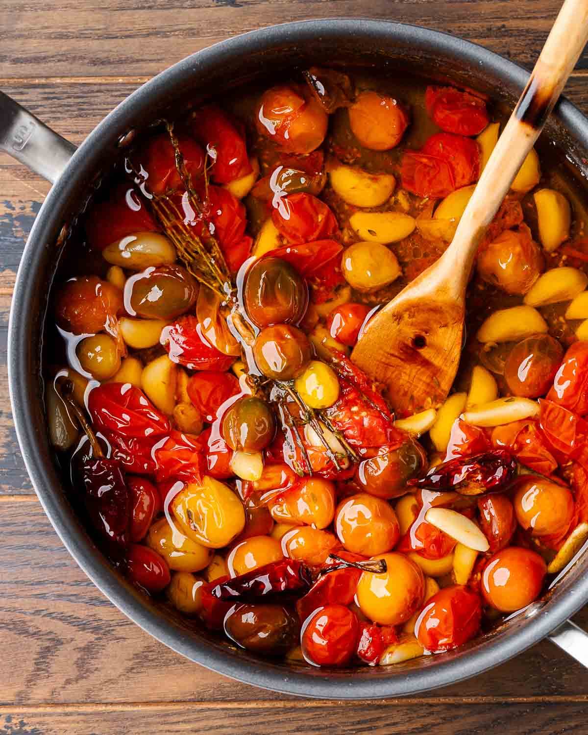 Overhead shot of large pan with tomato garlic confit.